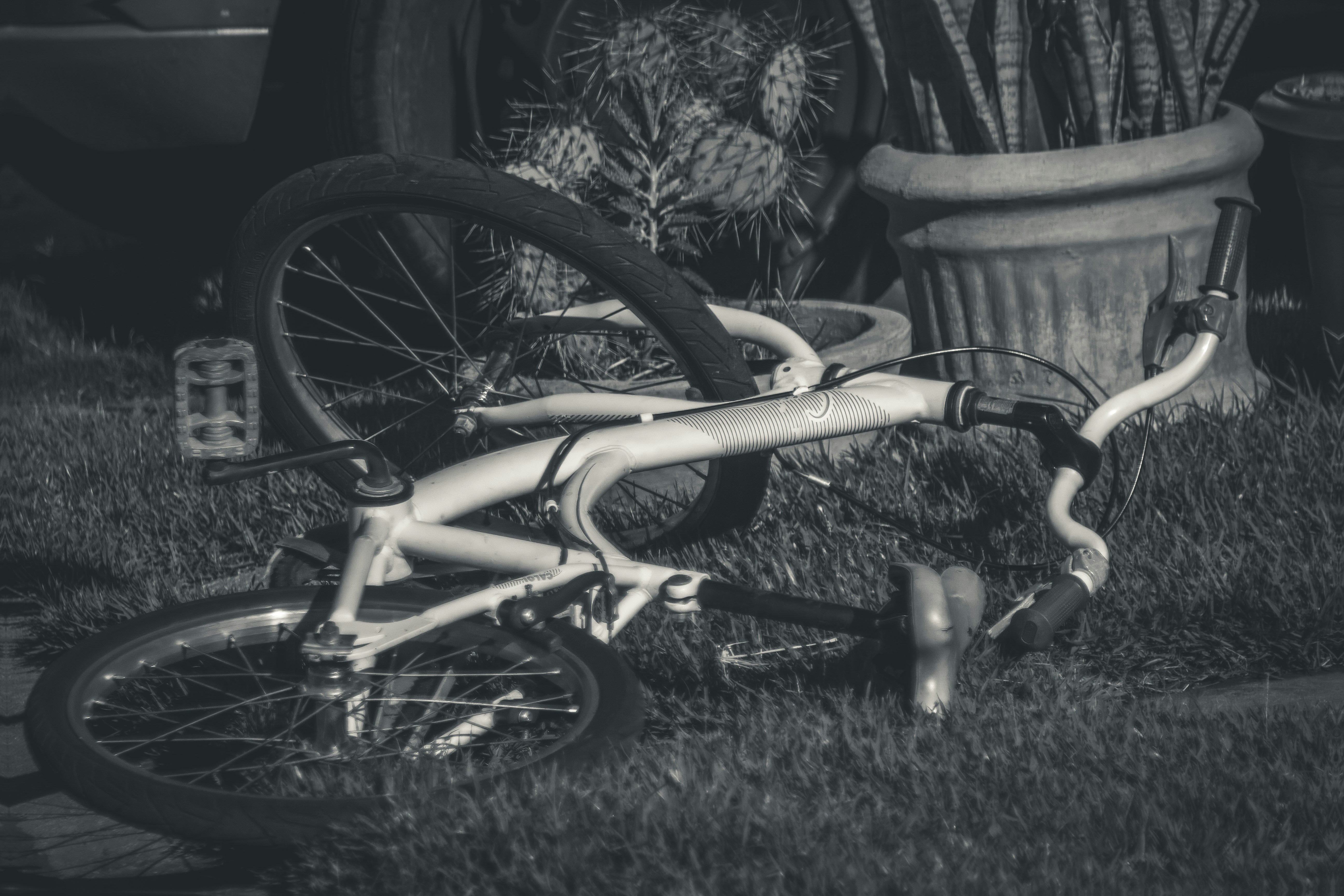 A white bmx bicycle lying on the grass.