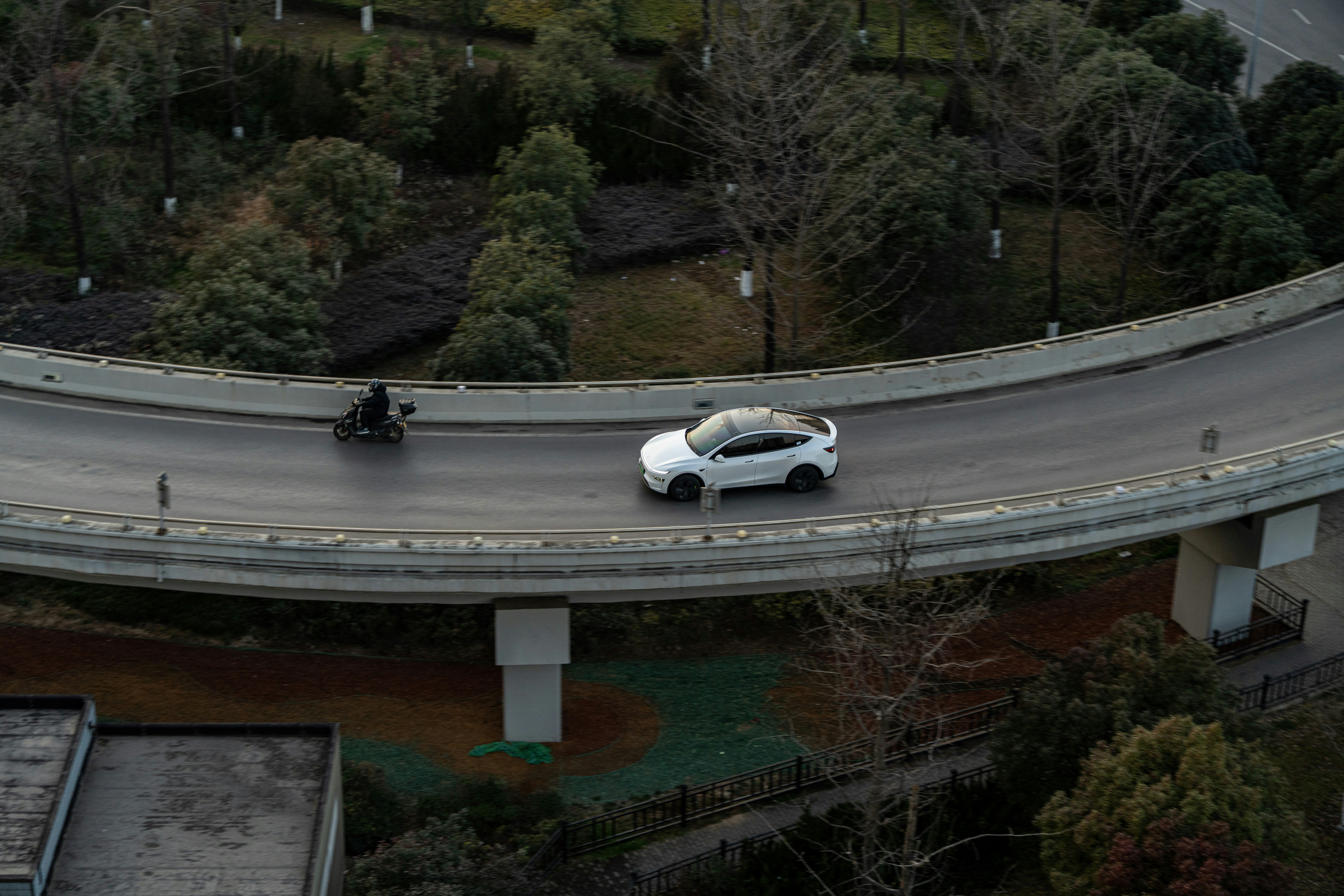 A white car drives on an elevated road.