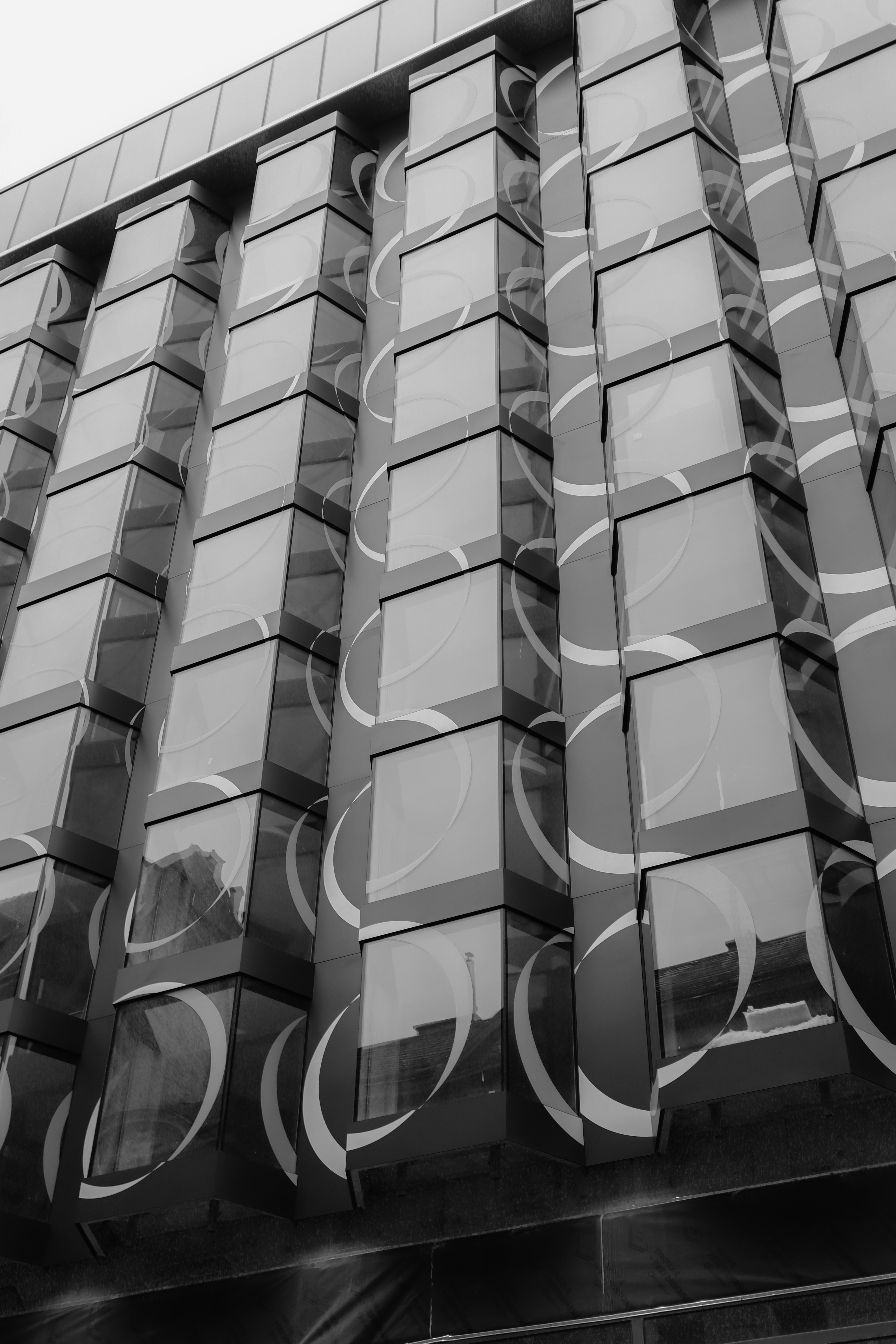 Façade moderne du bâtiment avec verre réfléchissant et motifs en spirale