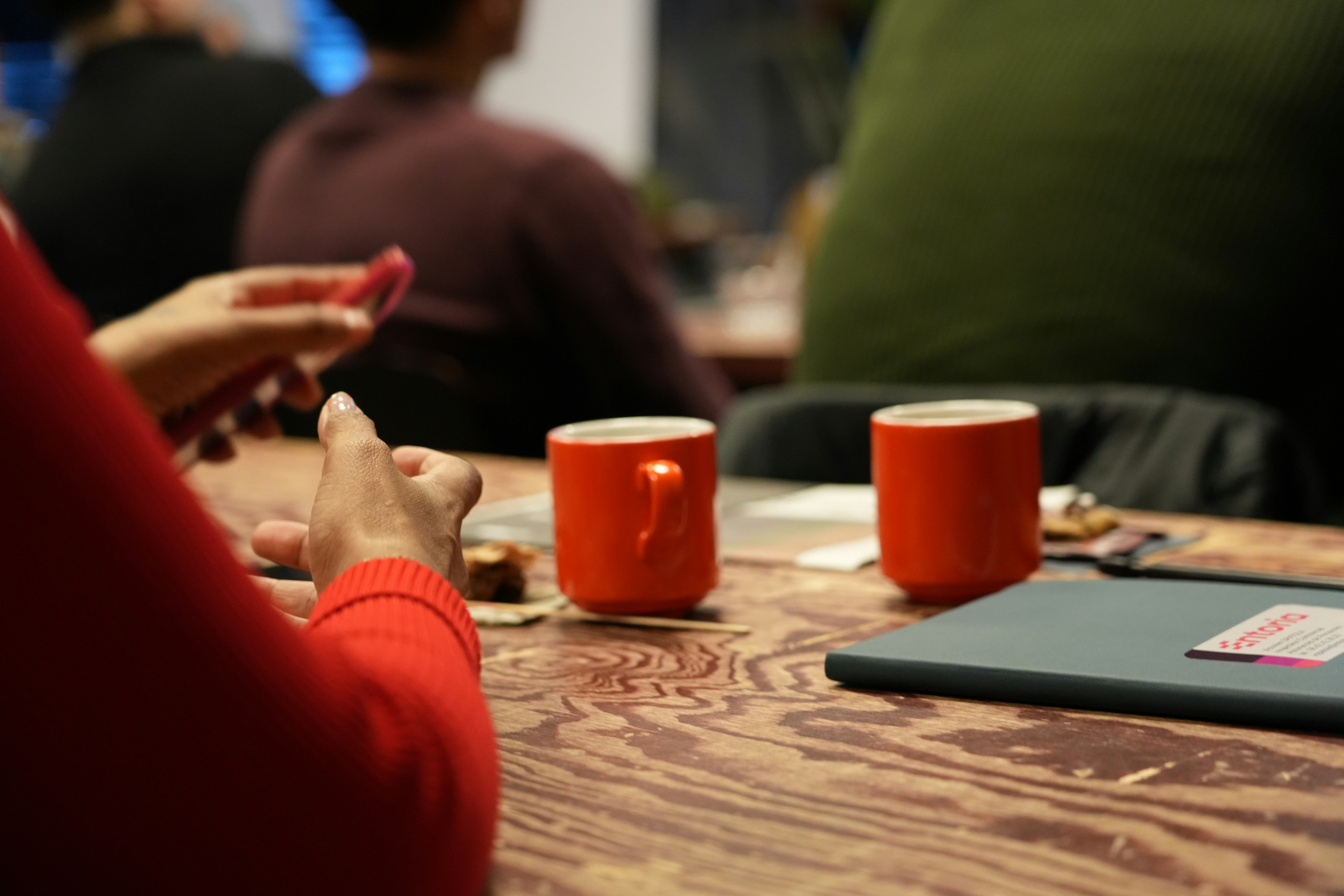 Two orange mugs on a wooden table
