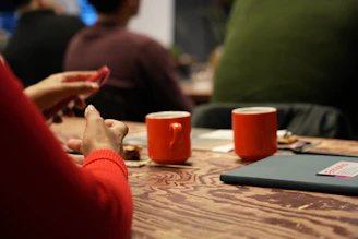 Two orange mugs on a wooden table