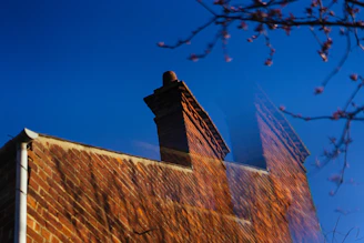 Brick chimney on a building against a blue sky.