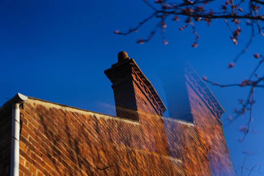 Brick chimney on a building against a blue sky.