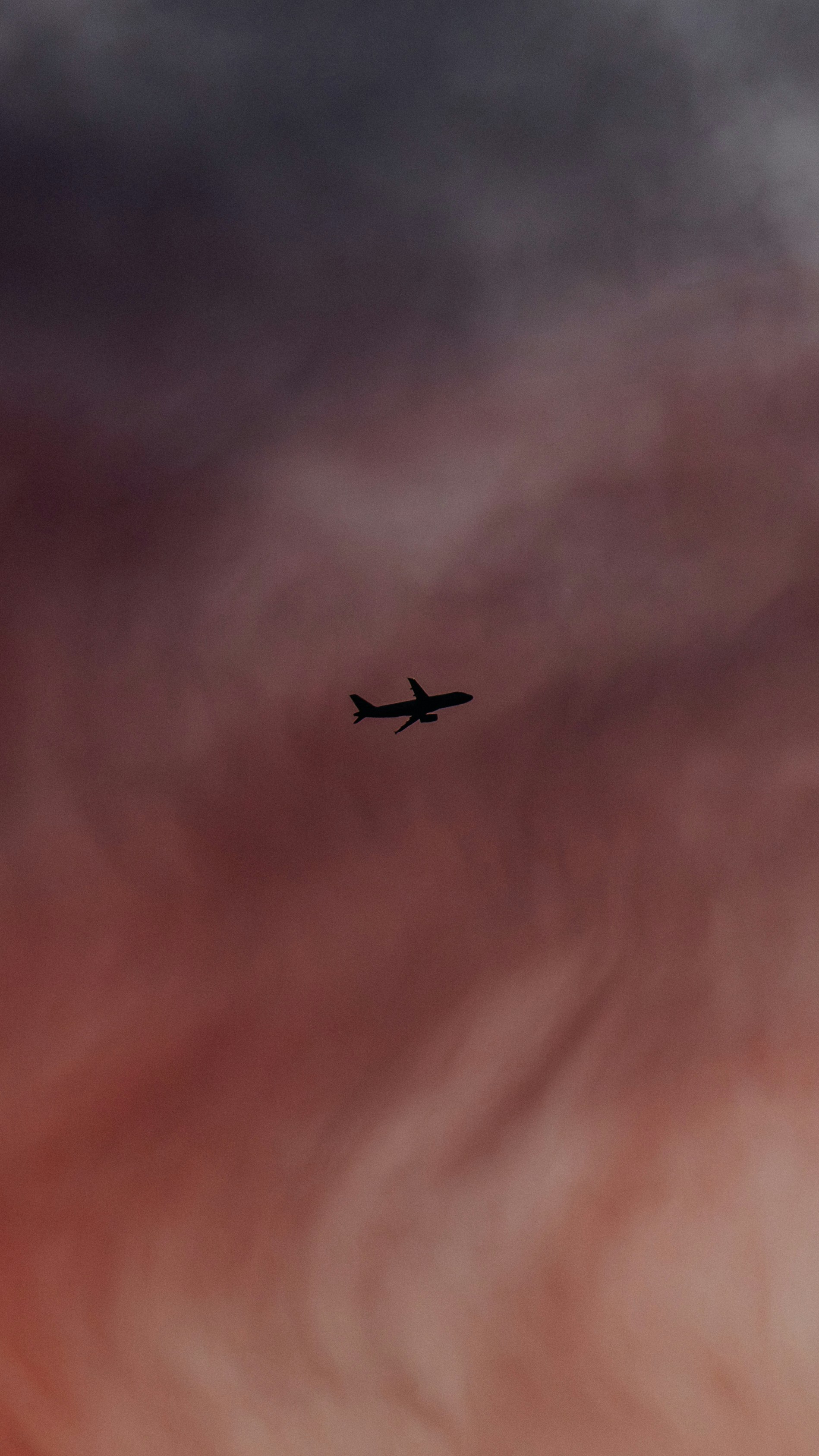 Airplane silhouette against a dramatic sunset sky