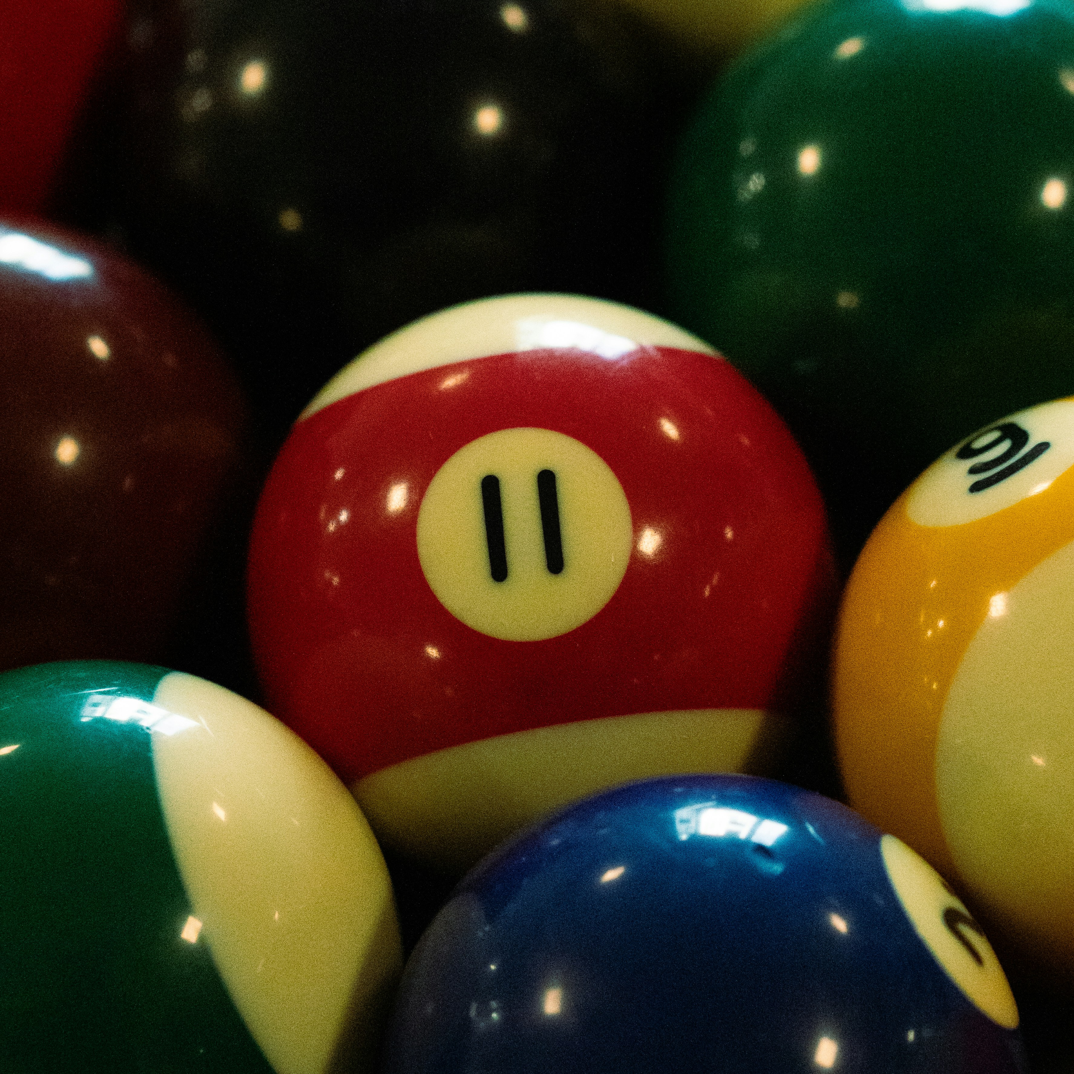 Close-up of billiard balls with number eleven prominent.