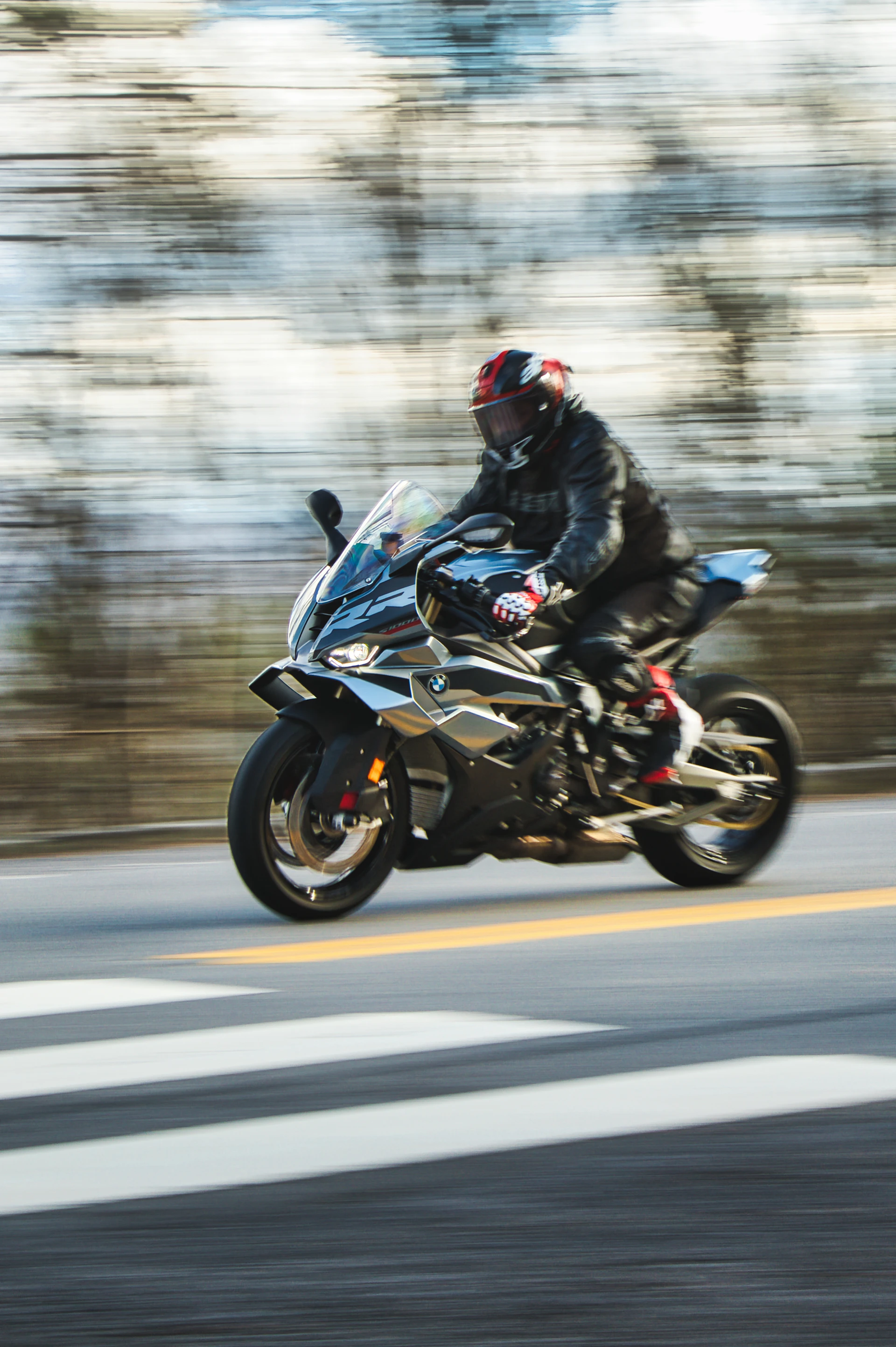 Motorcyclist riding a sleek sport bike on a road.