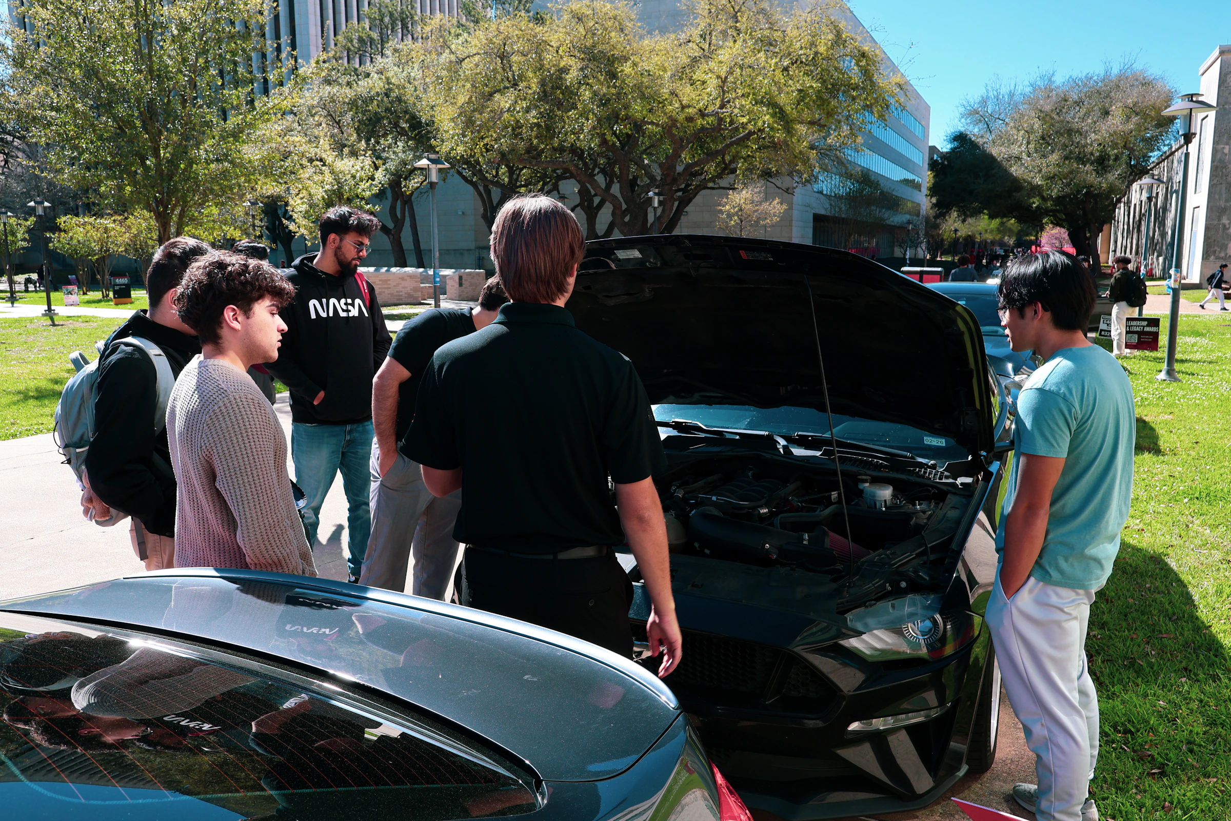 Group inspecting car engine