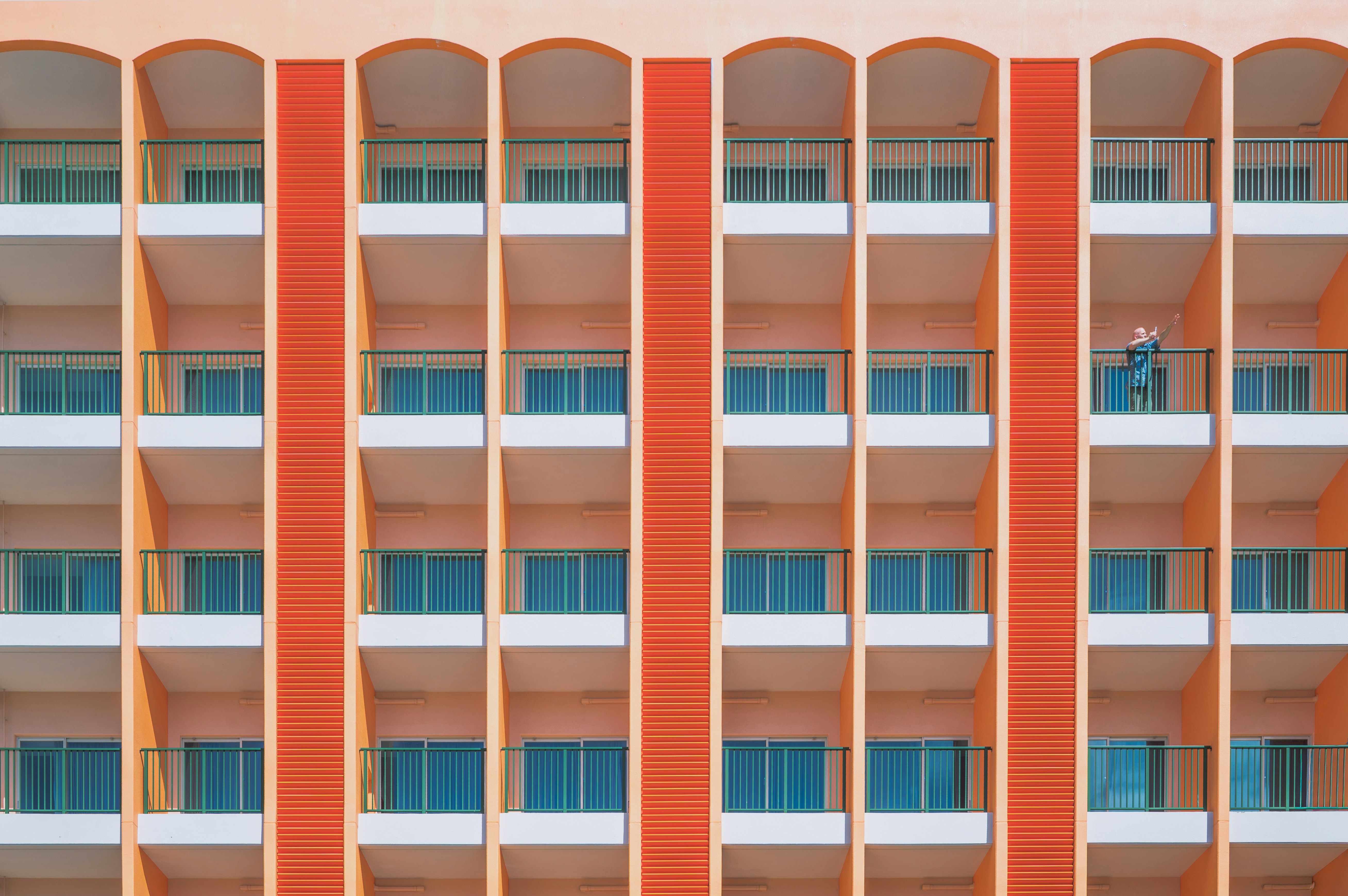 Orange building facade with repeating balconies and windows