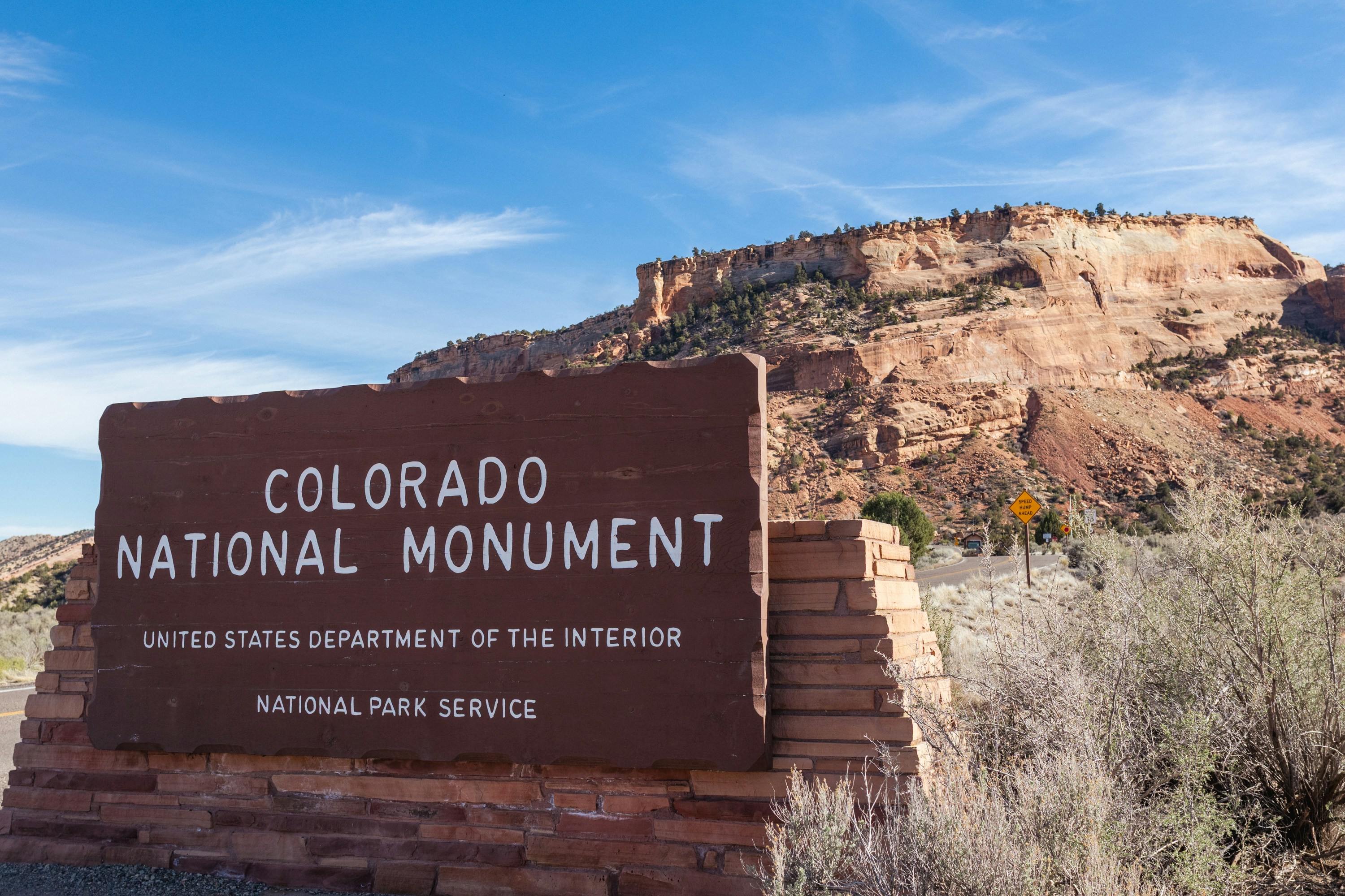 Colorado national monument sign with rock formations behind