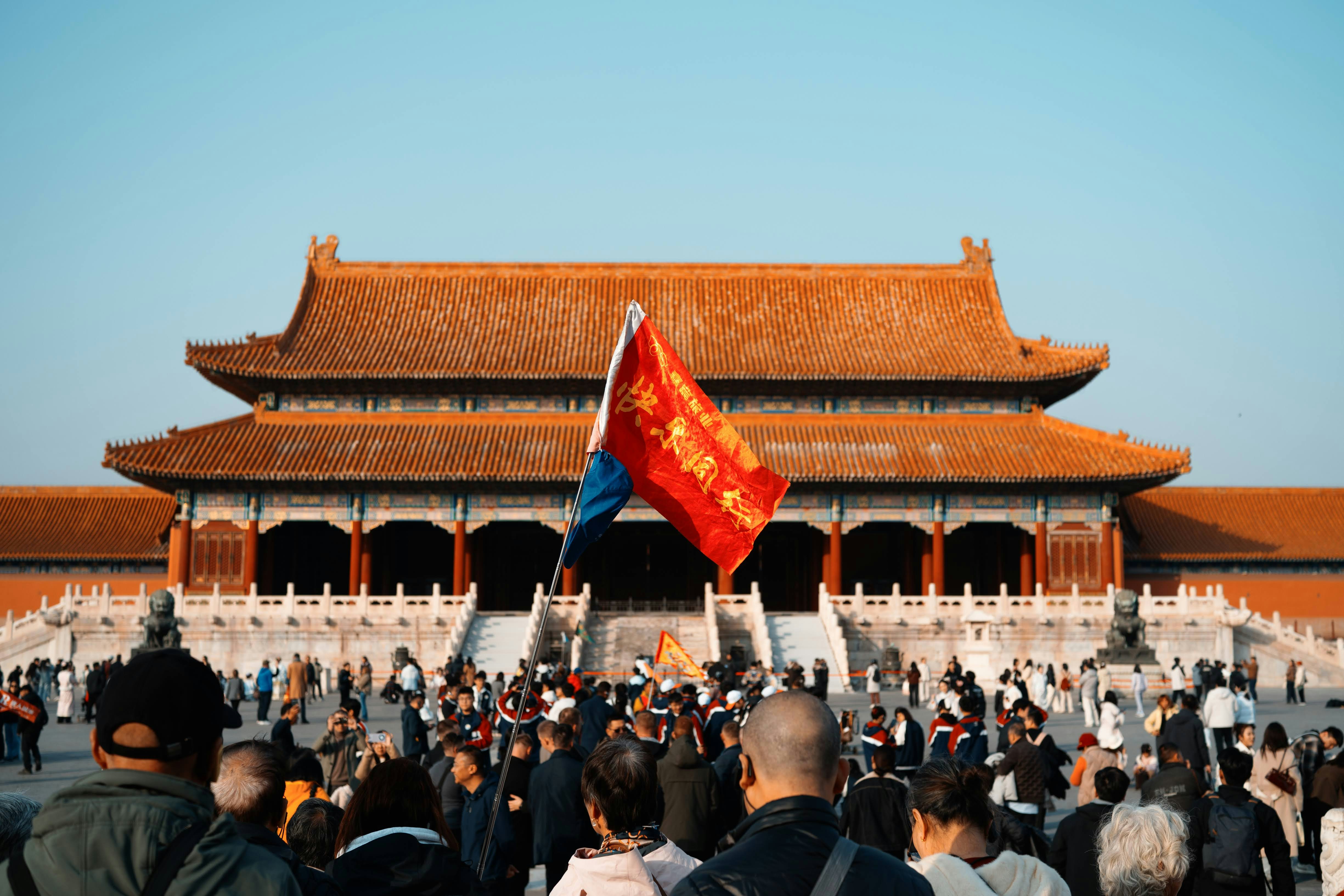 Crowd gathered in front of a large traditional chinese building.