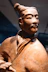 Terracotta warrior statue with traditional hairstyle and historical clothing.