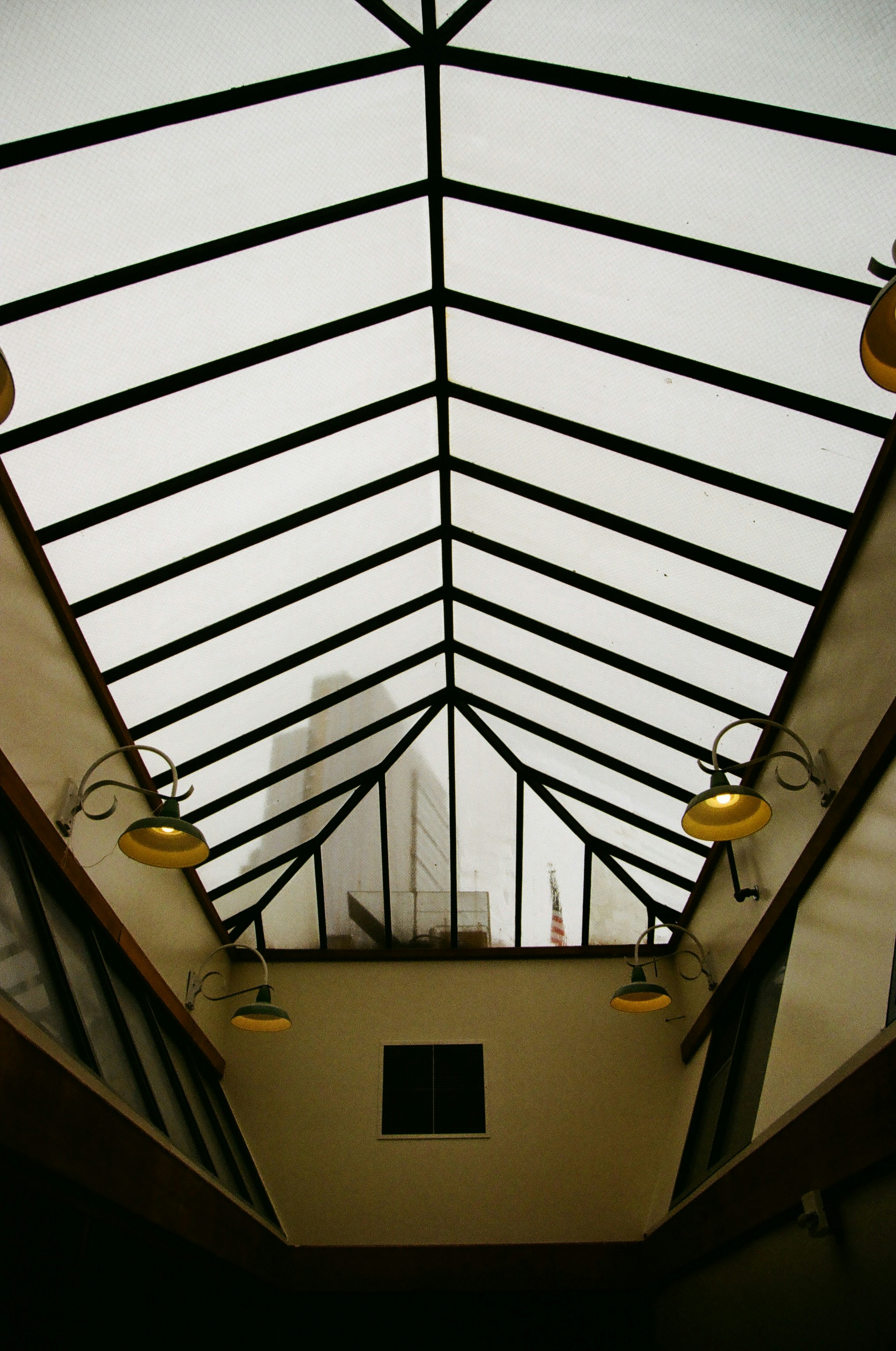 Soffitto geometrico con lampadari moderni.