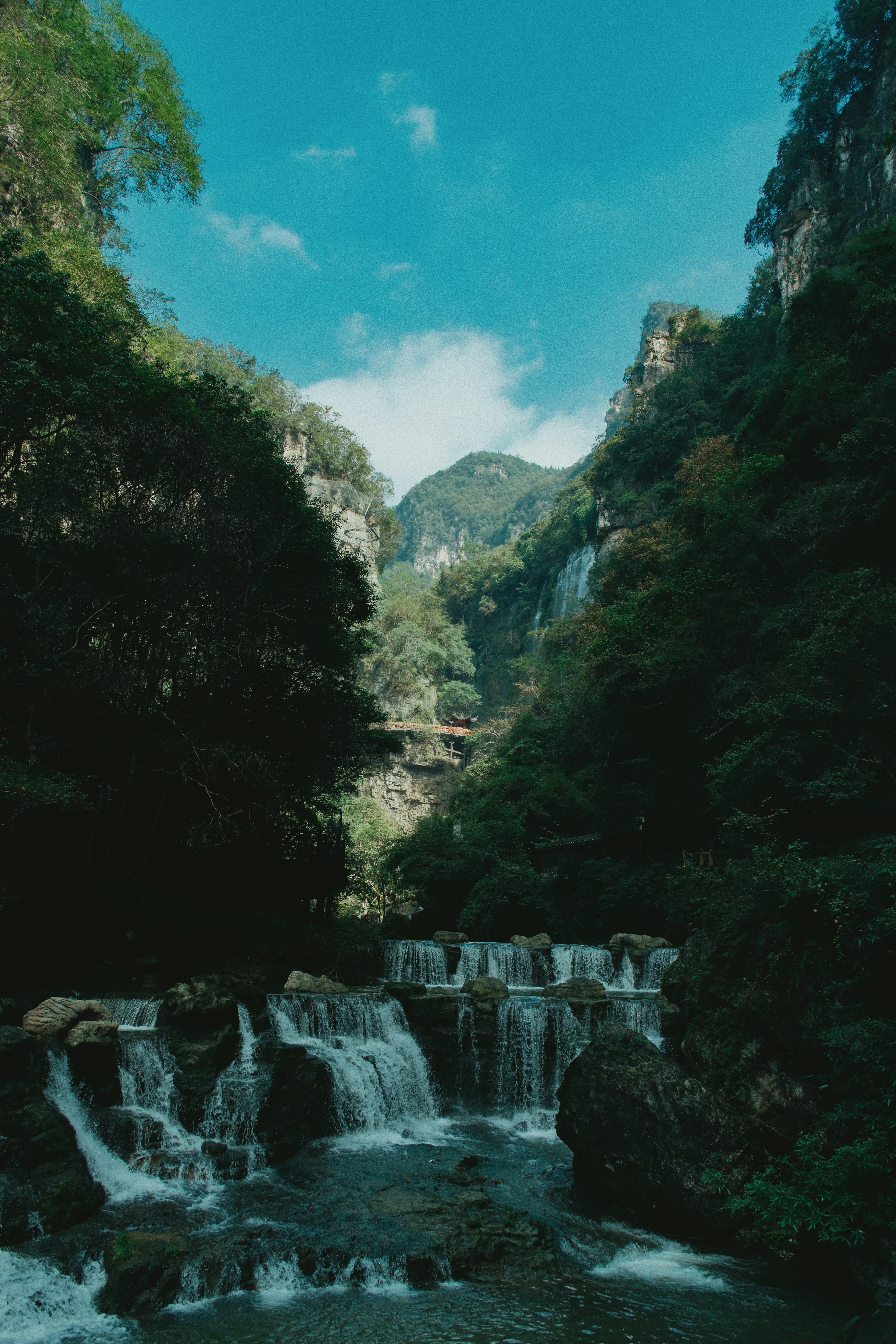 Air terjun mengalir melalui ngarai hijau yang subur.