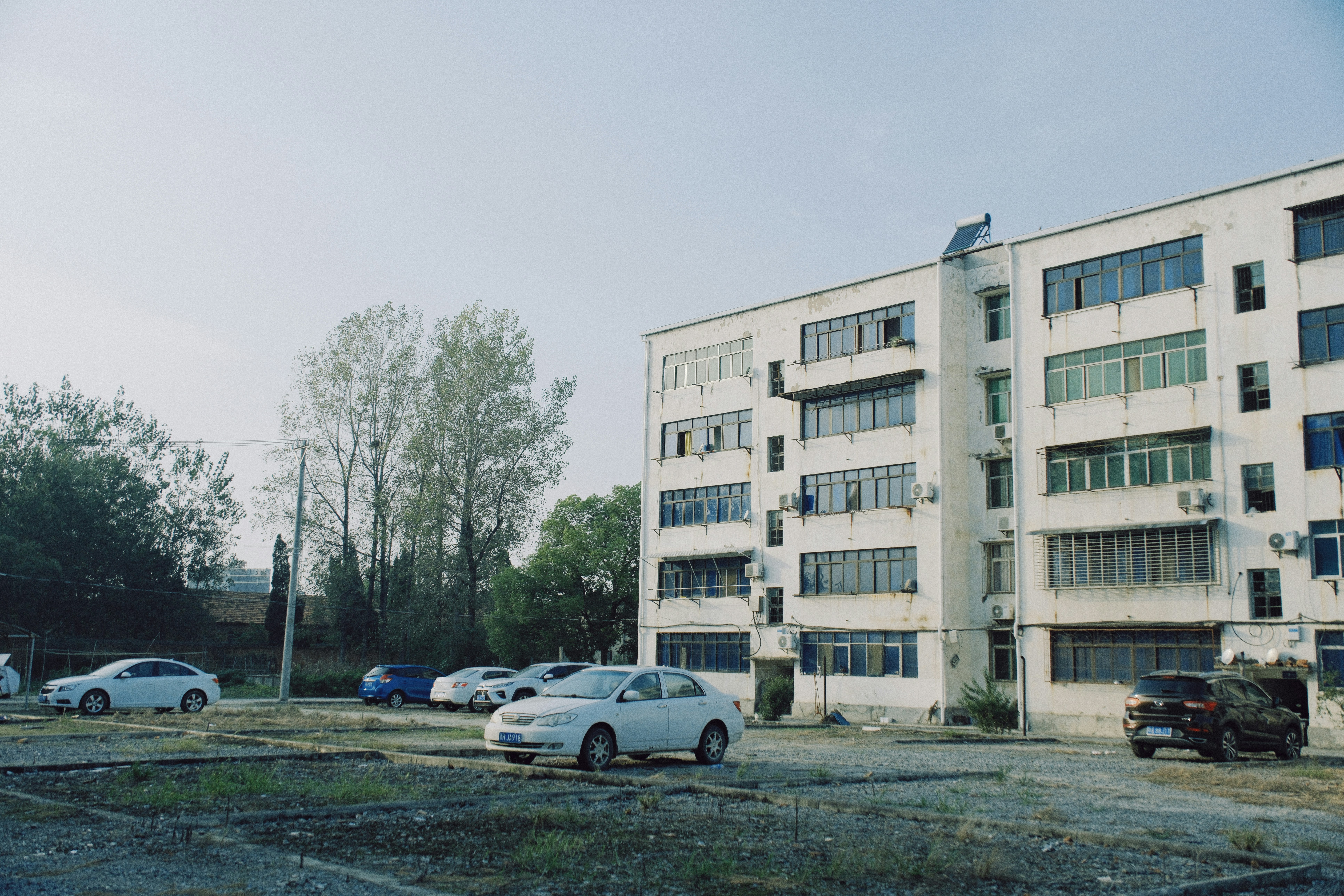 Gedung apartemen dengan mobil yang diparkir di banyak tempat.
