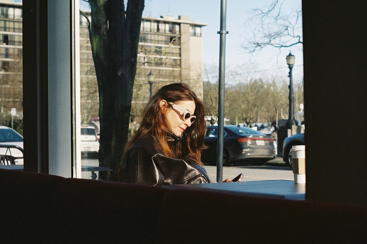 A woman looking at her phone inside a cafe