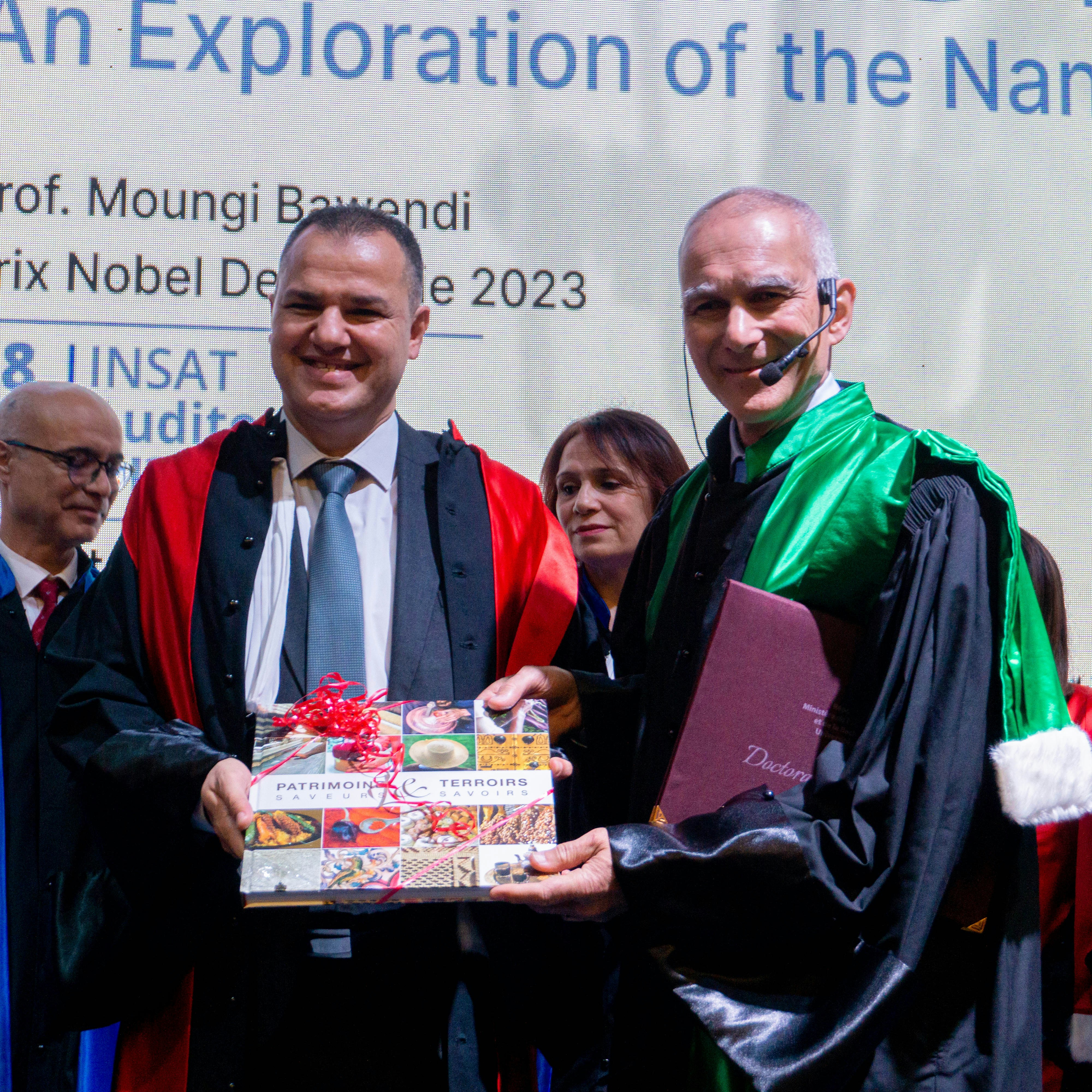 Two men in academic regalia receiving an award