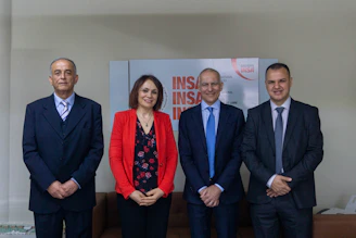 Four people posing for a formal group portrait