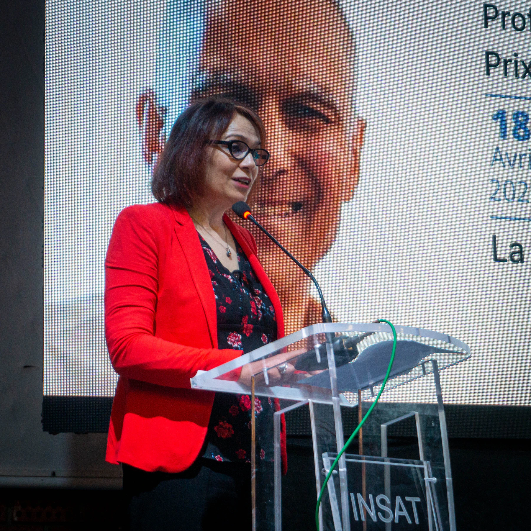 A woman speaking at a conference podium