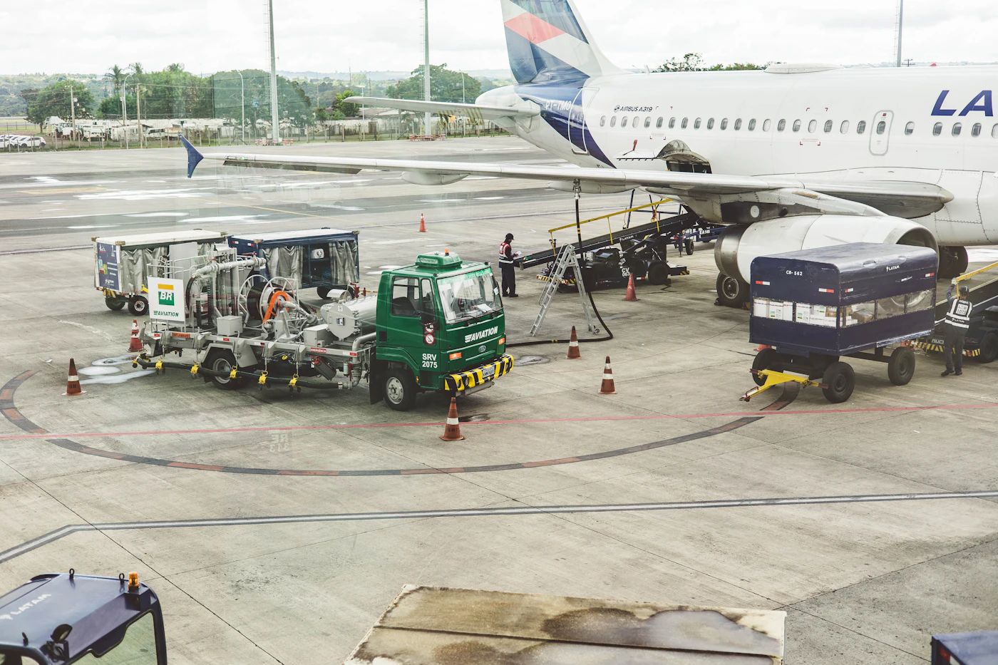 An airplane being refueled on the tarmac at an airport