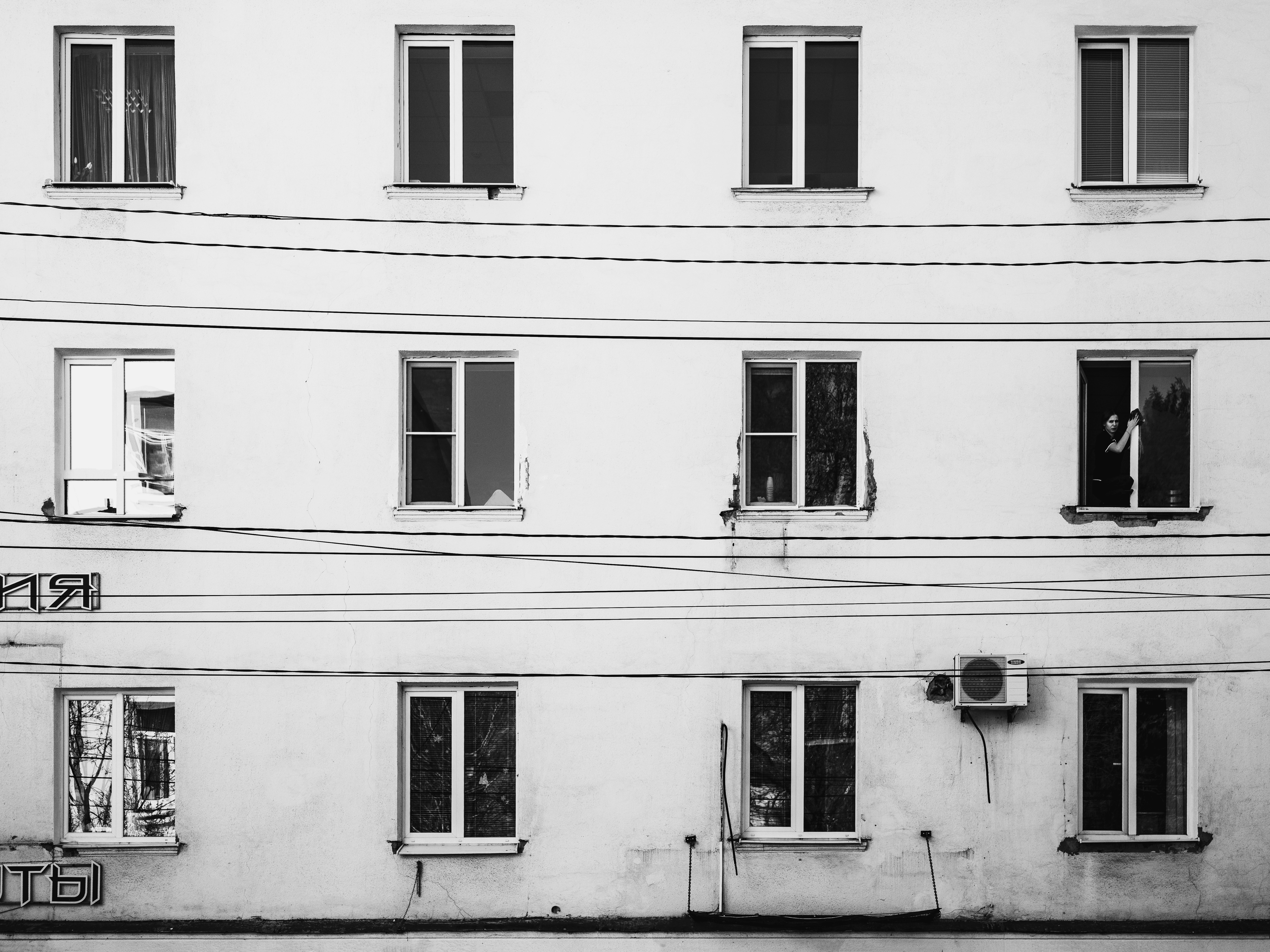White building facade with multiple windows and wires.