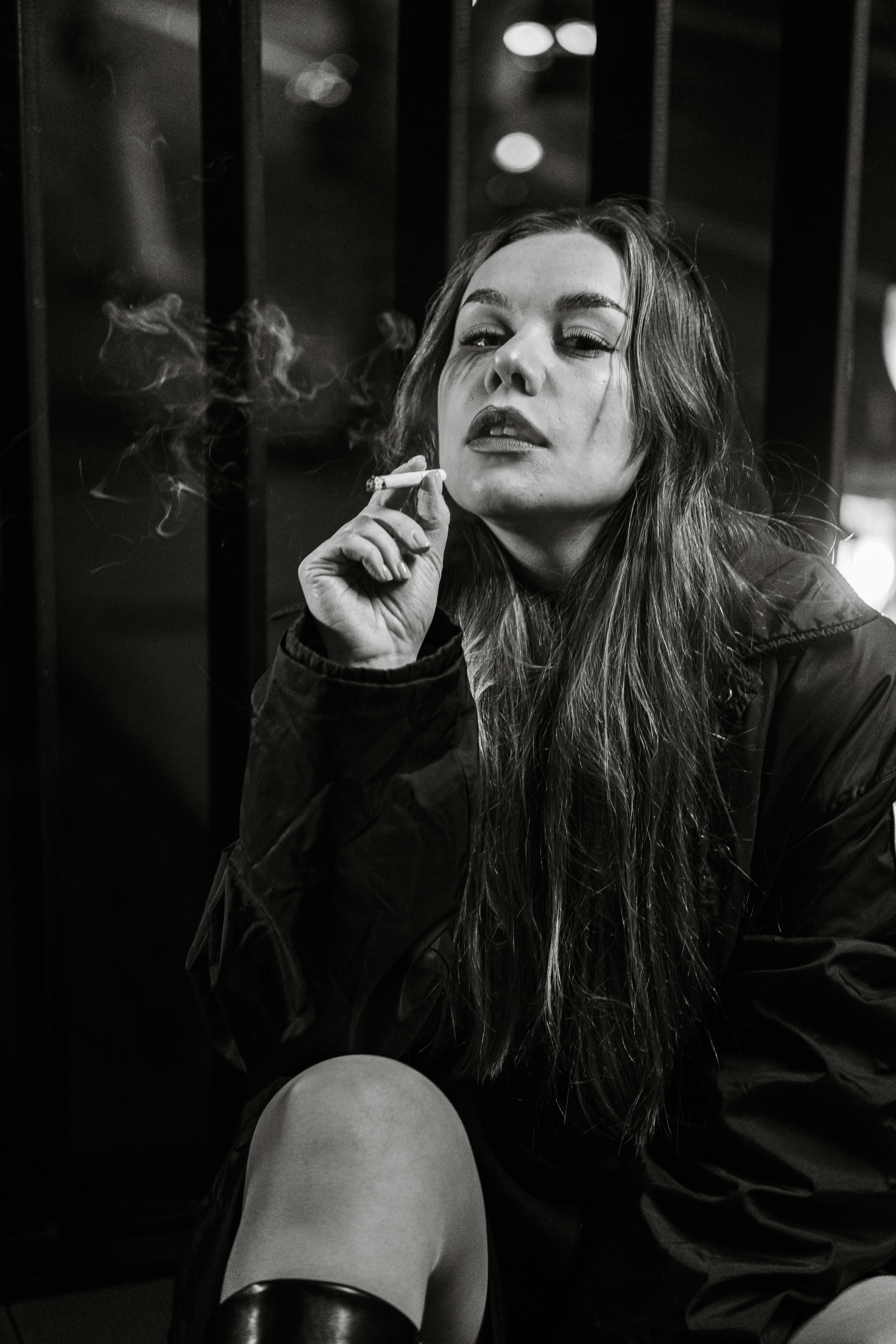 A woman smoking a cigarette with smoke rising