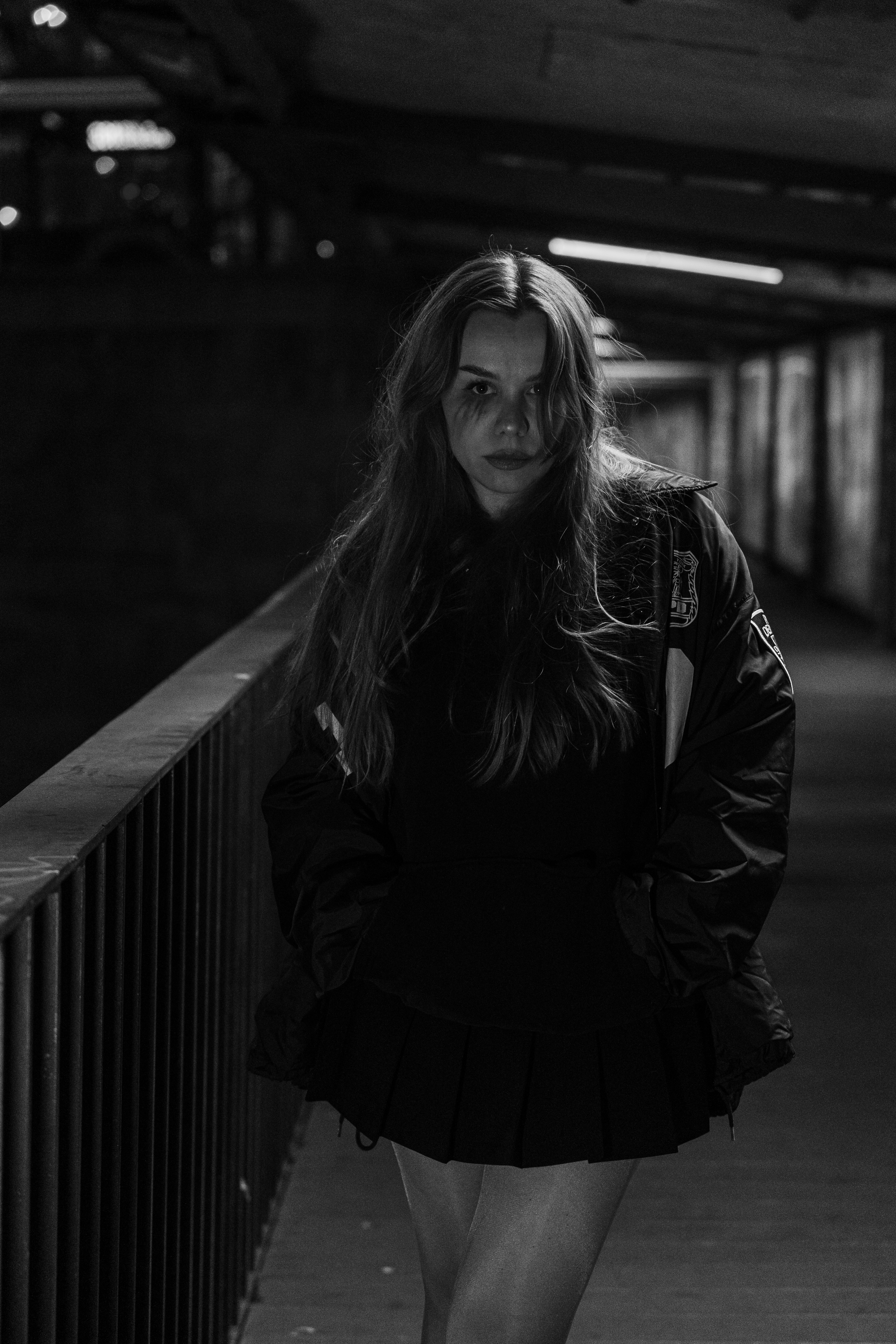 Young woman with long hair in a dark hallway.
