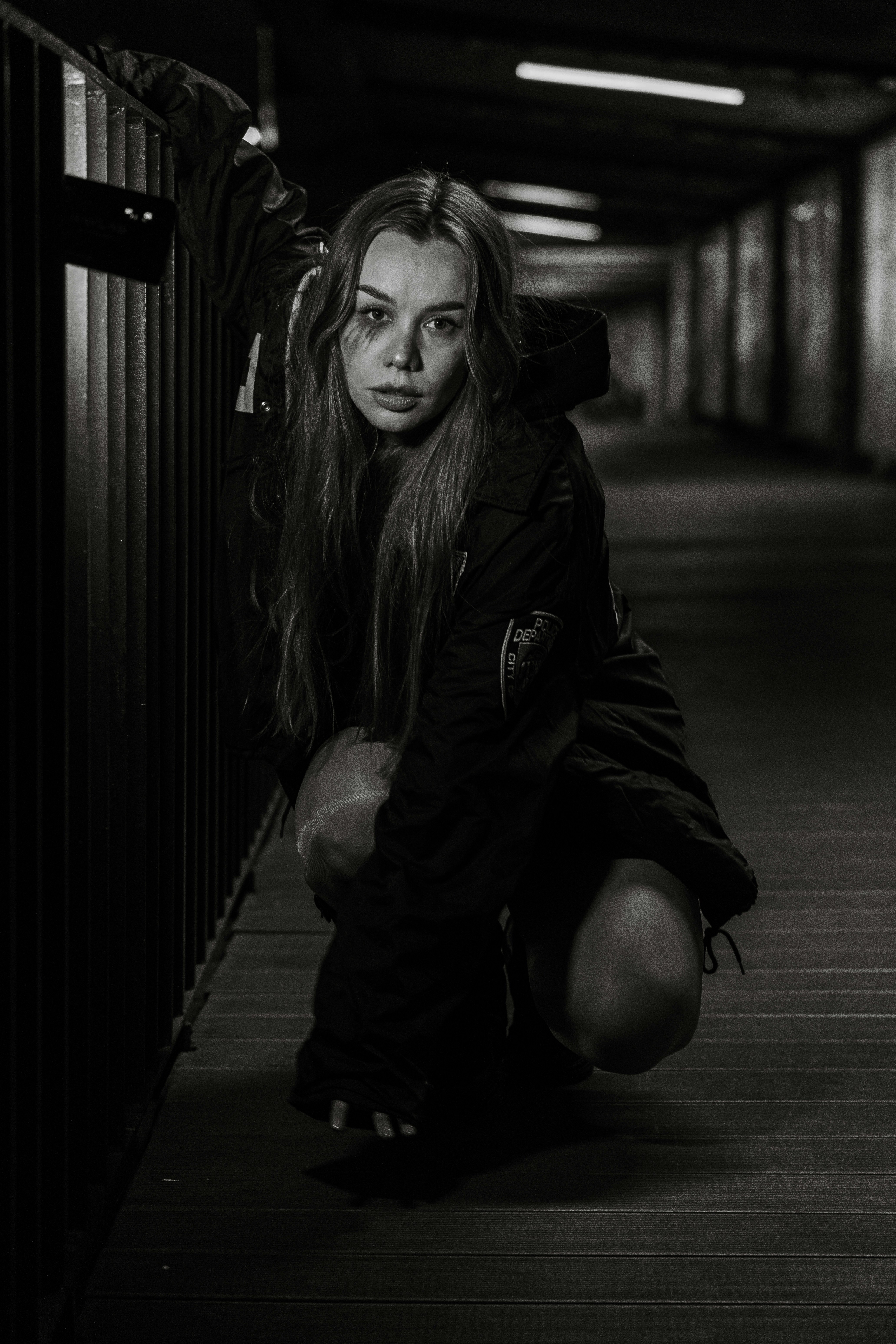 Woman crouching in a dark tunnel