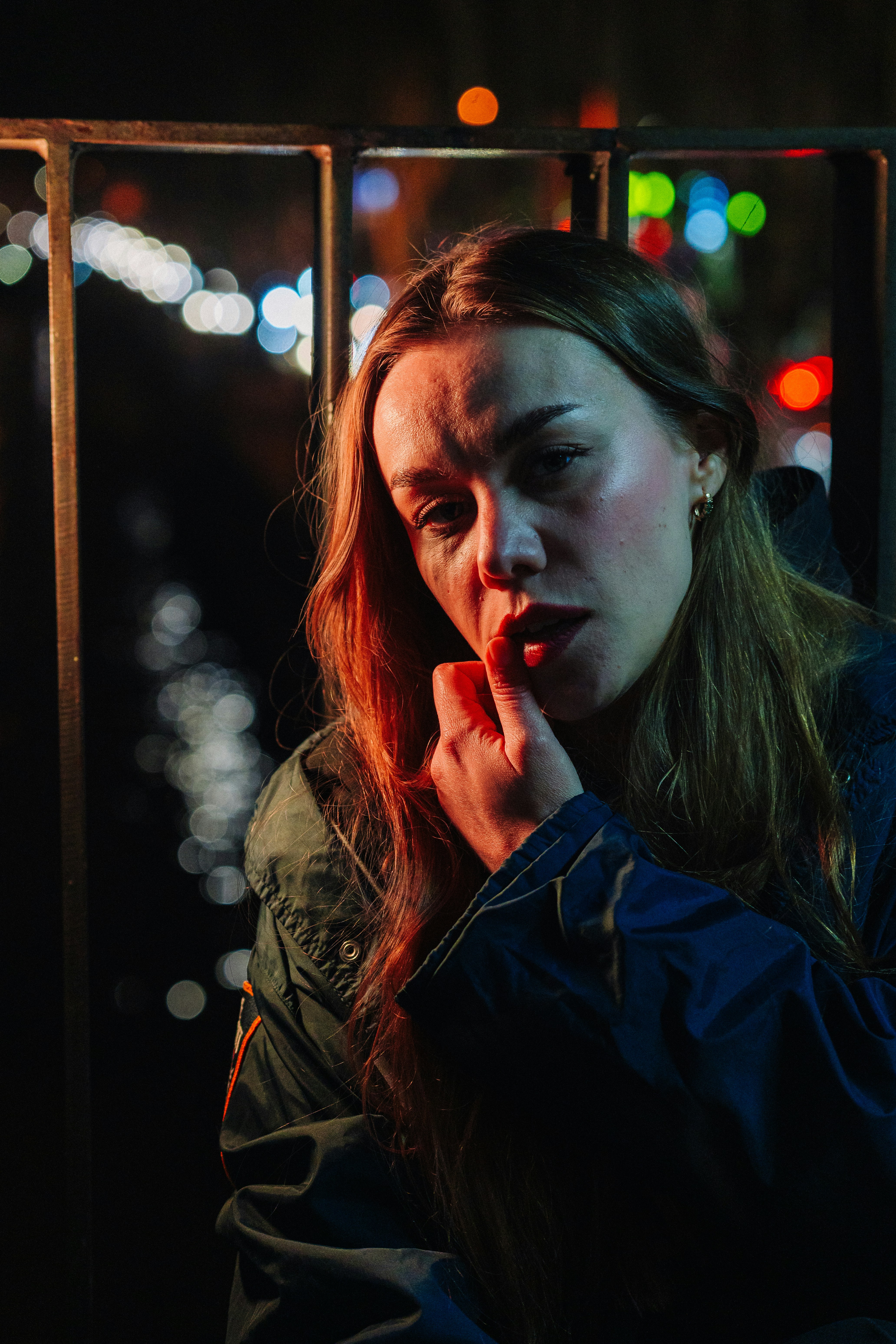 Woman with finger on lips in dim light