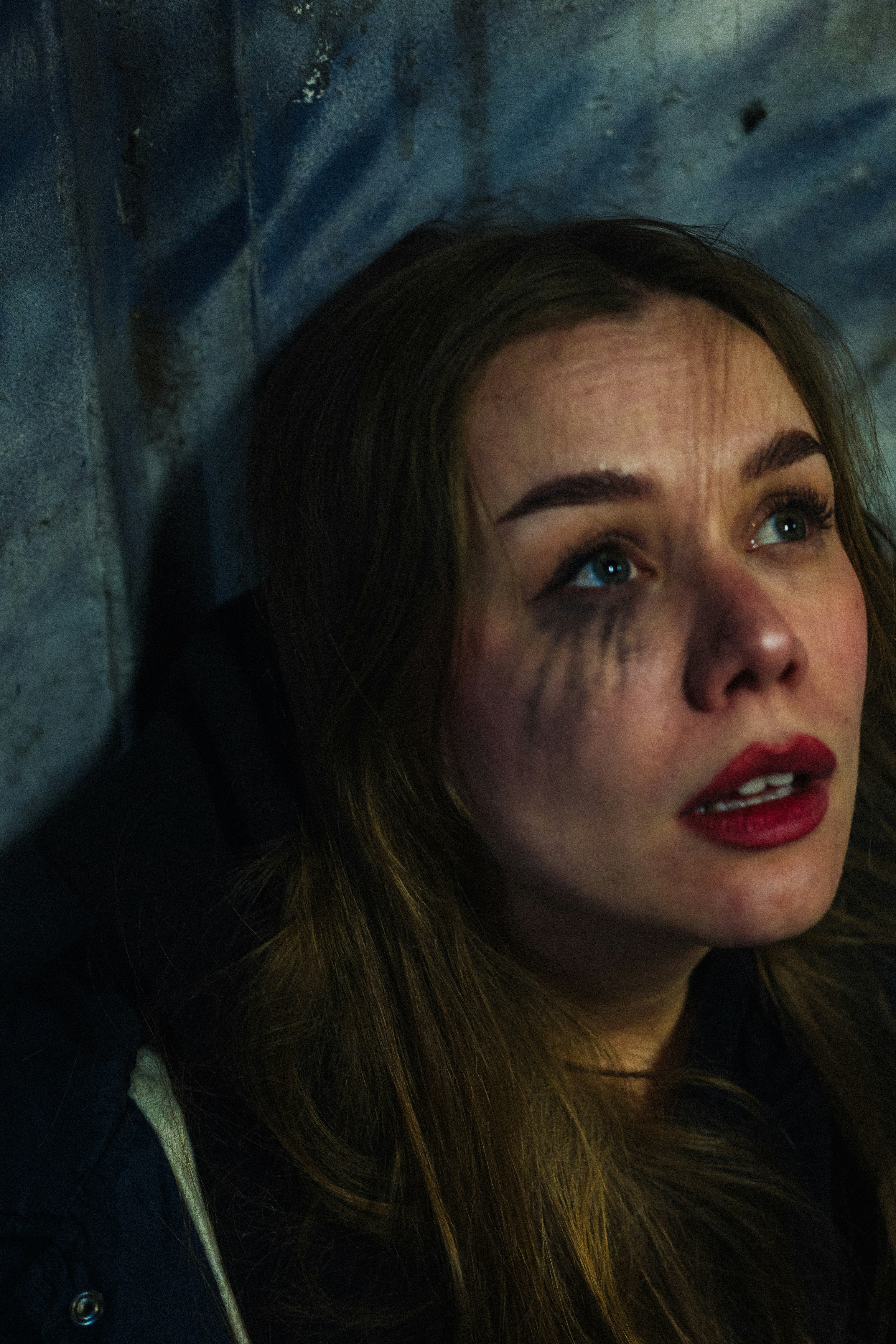 Woman with smudged makeup looking upwards.