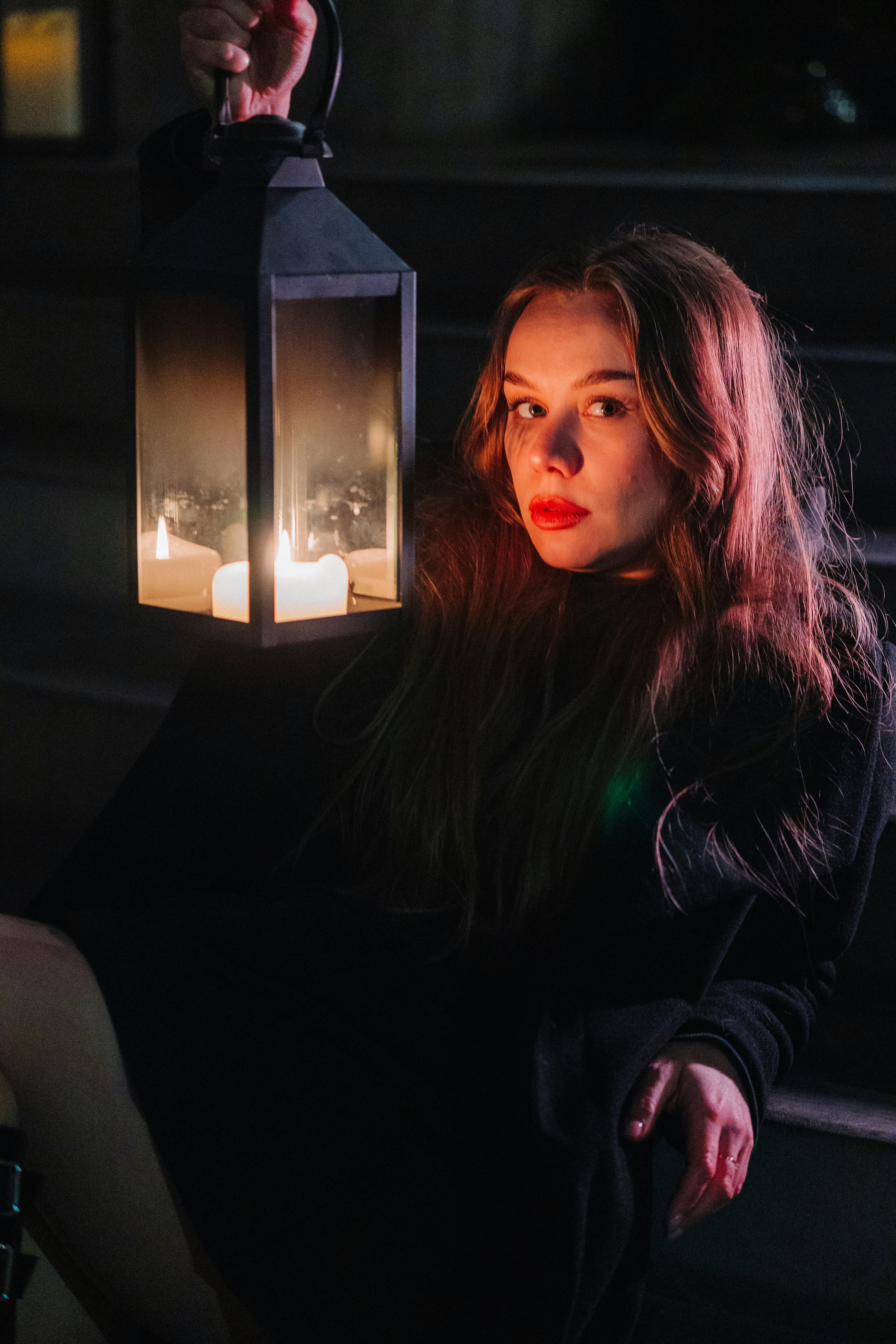 Woman holding a lantern with lit candles