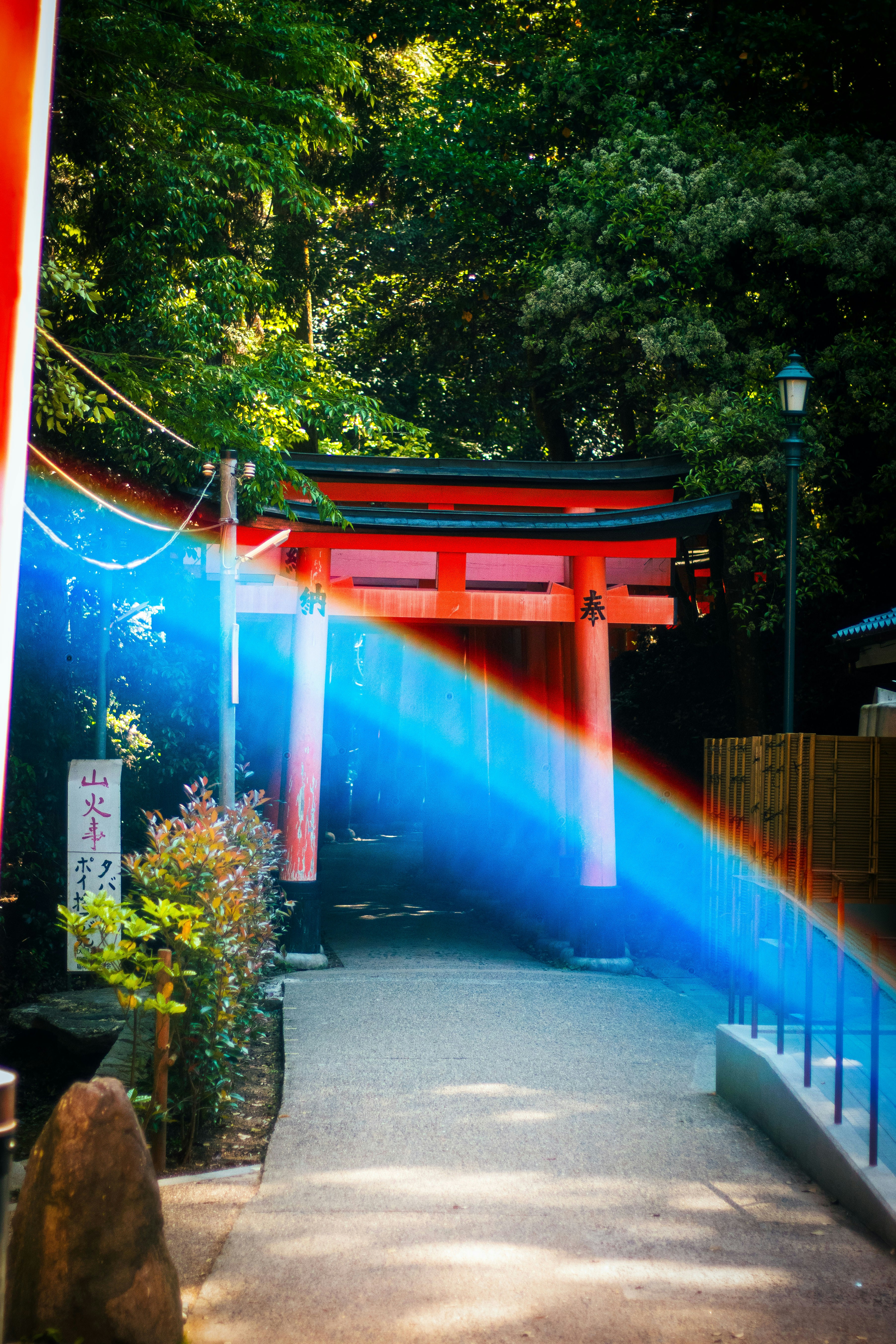 Red torii gate with rainbow light flare