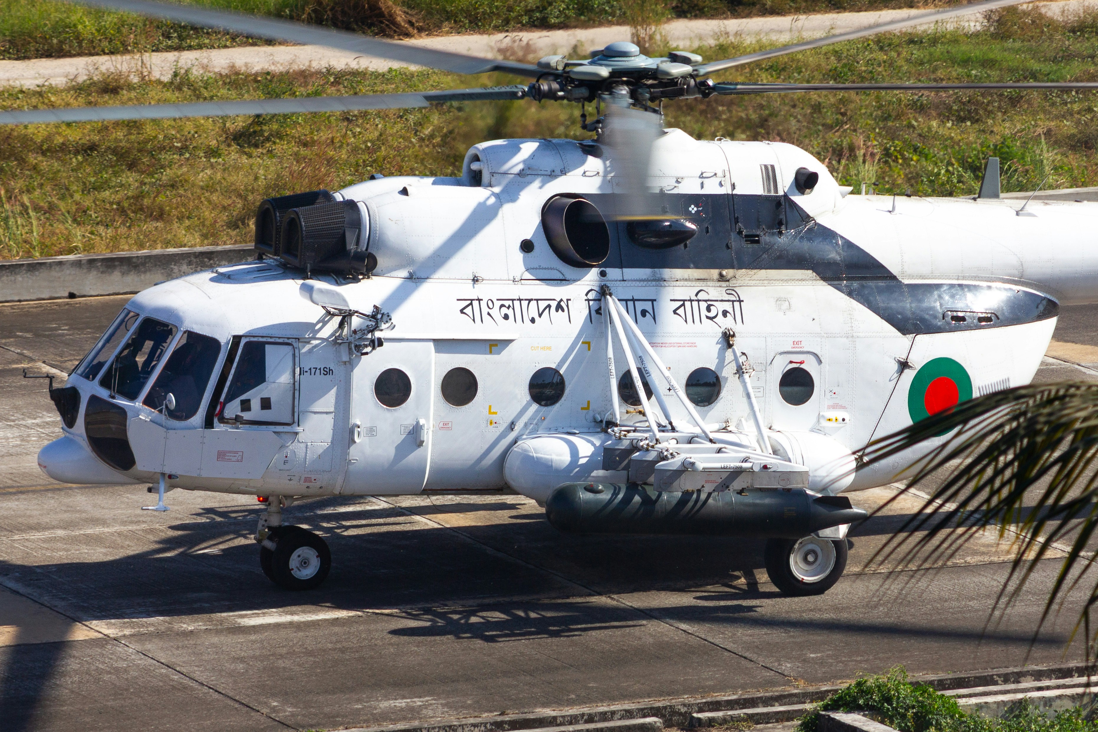 방글라데시 표시가 있는 하얀 헬리콥터가 활주로에 있었다.