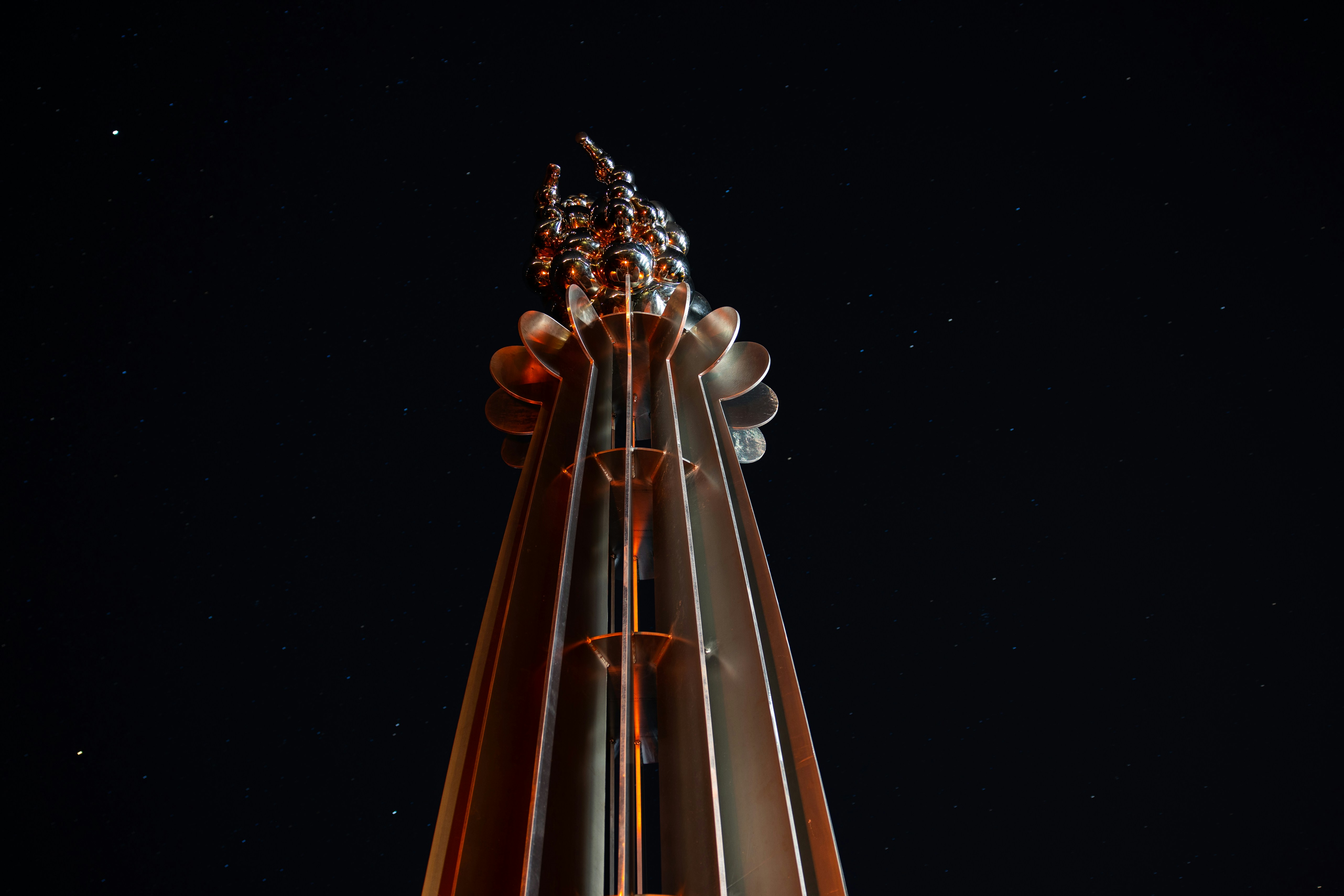 A metallic structure reaching towards a starry sky