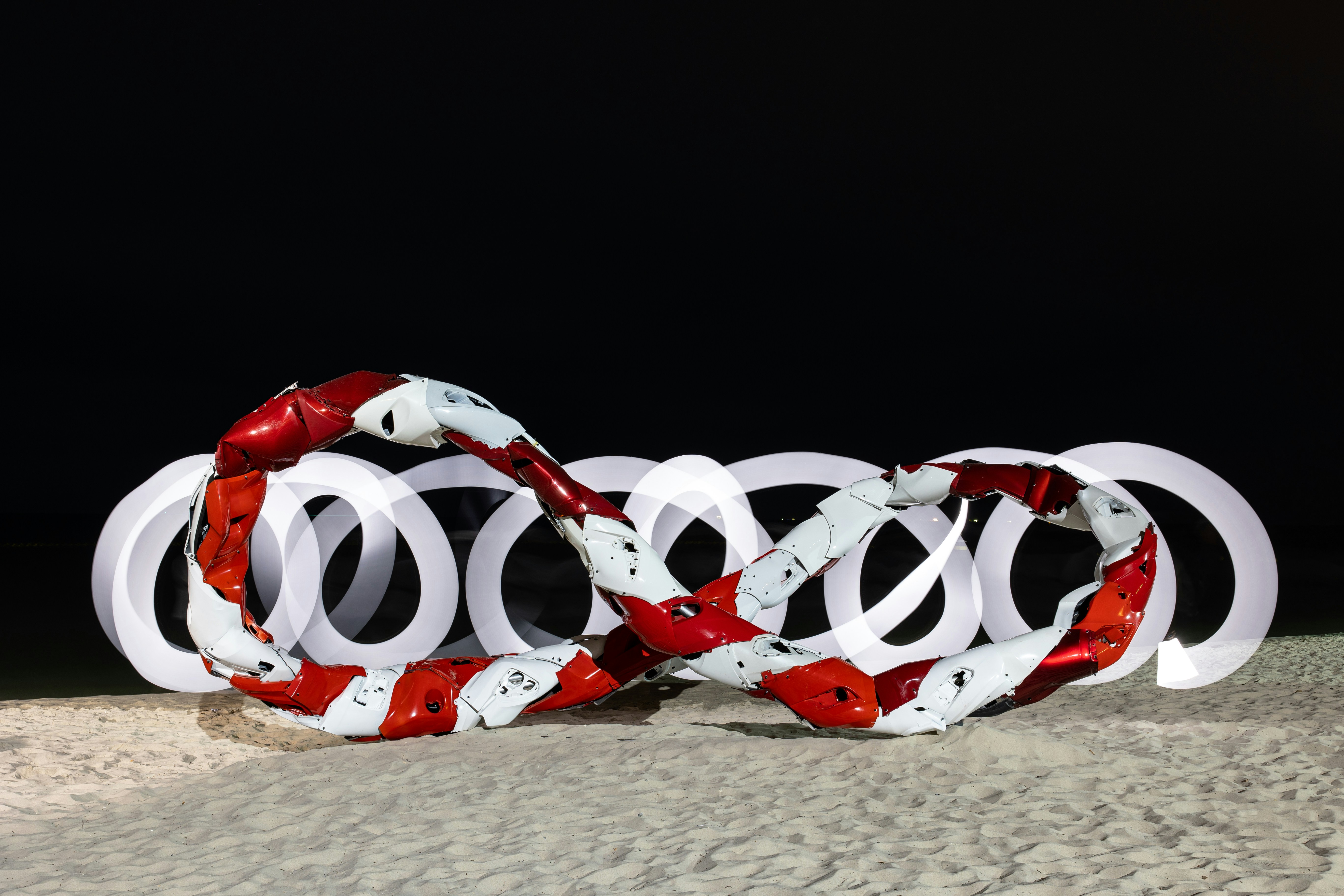 Red and white striped object forming infinity symbol