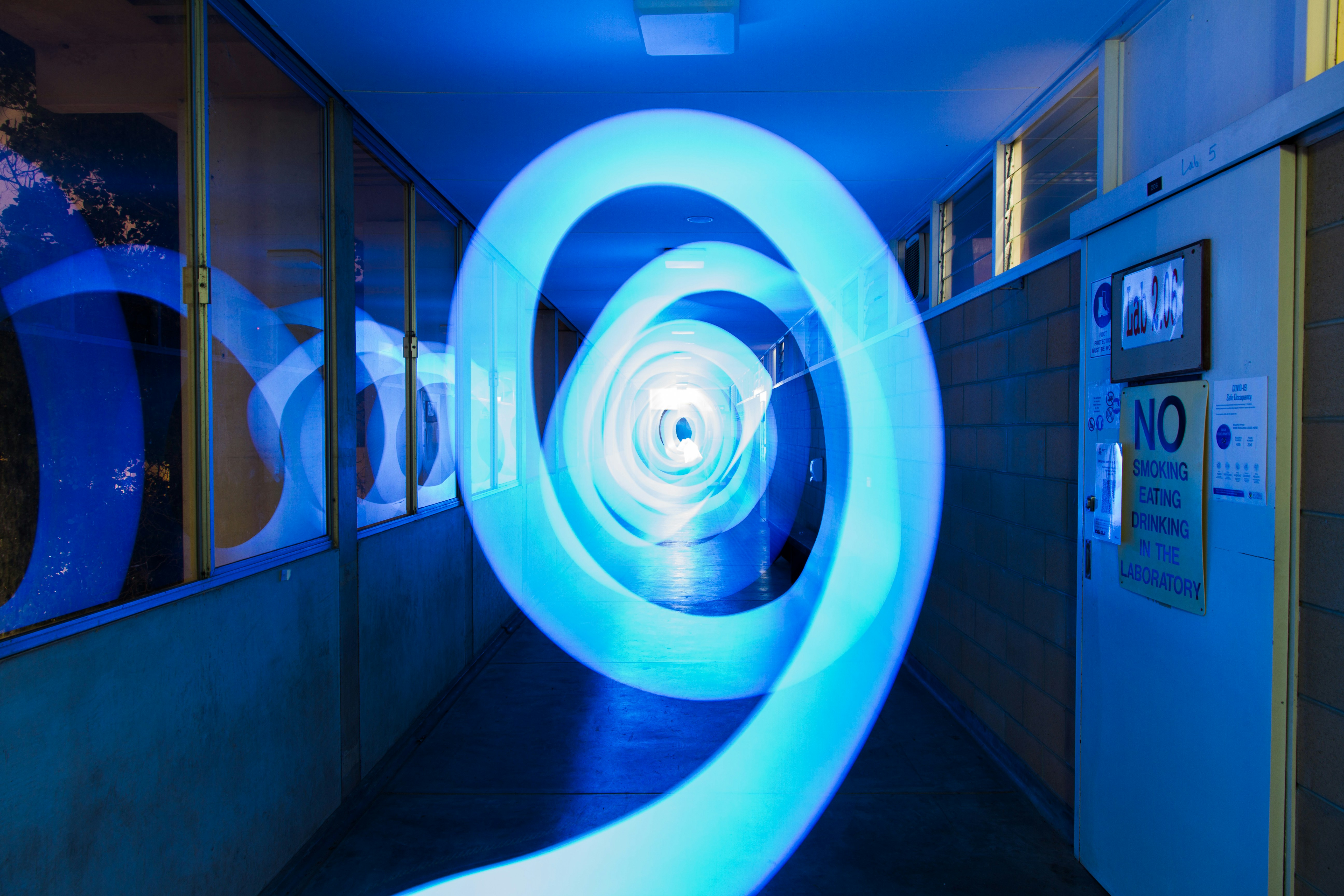 Blue light tunnel with swirling patterns in hallway