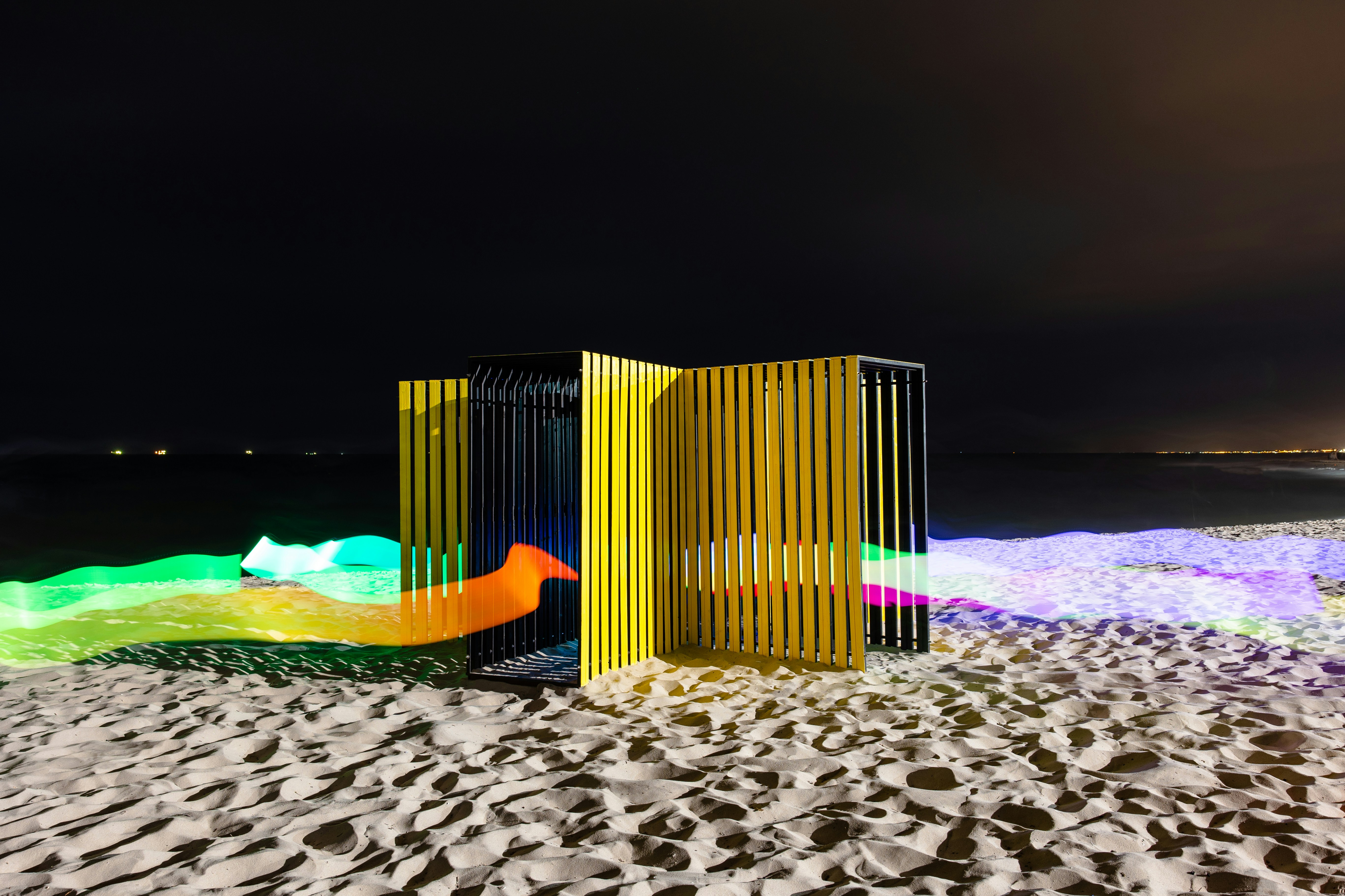 Modern art installation on a beach at night