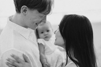 Parents looking at each other with baby between them