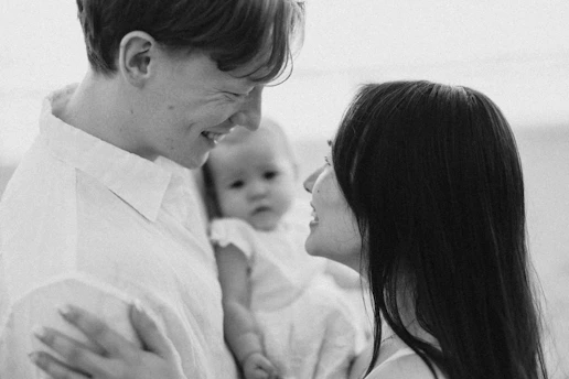 Parents looking at each other with baby between them