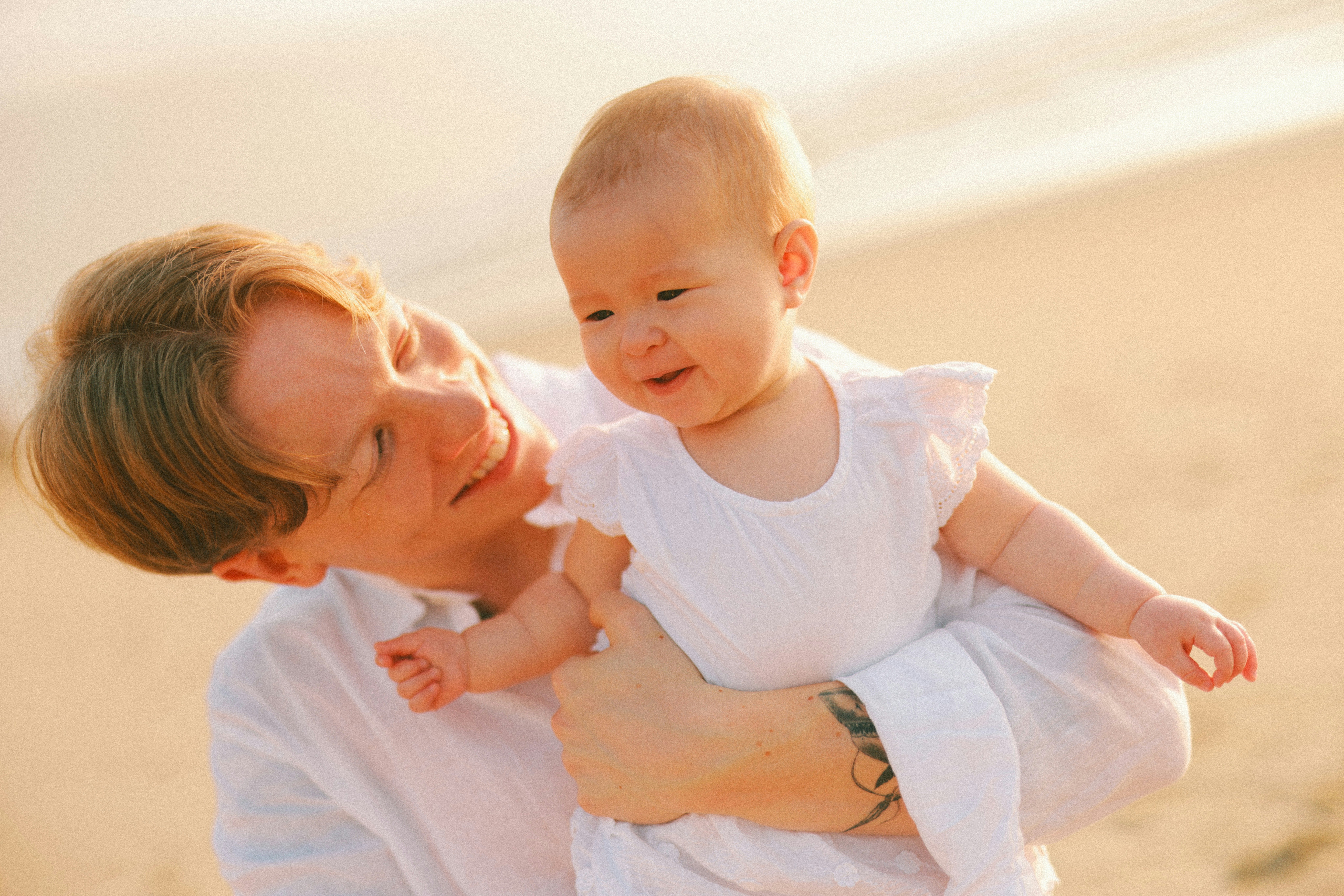 Father holding baby daughter on a beautiful beach at sunset