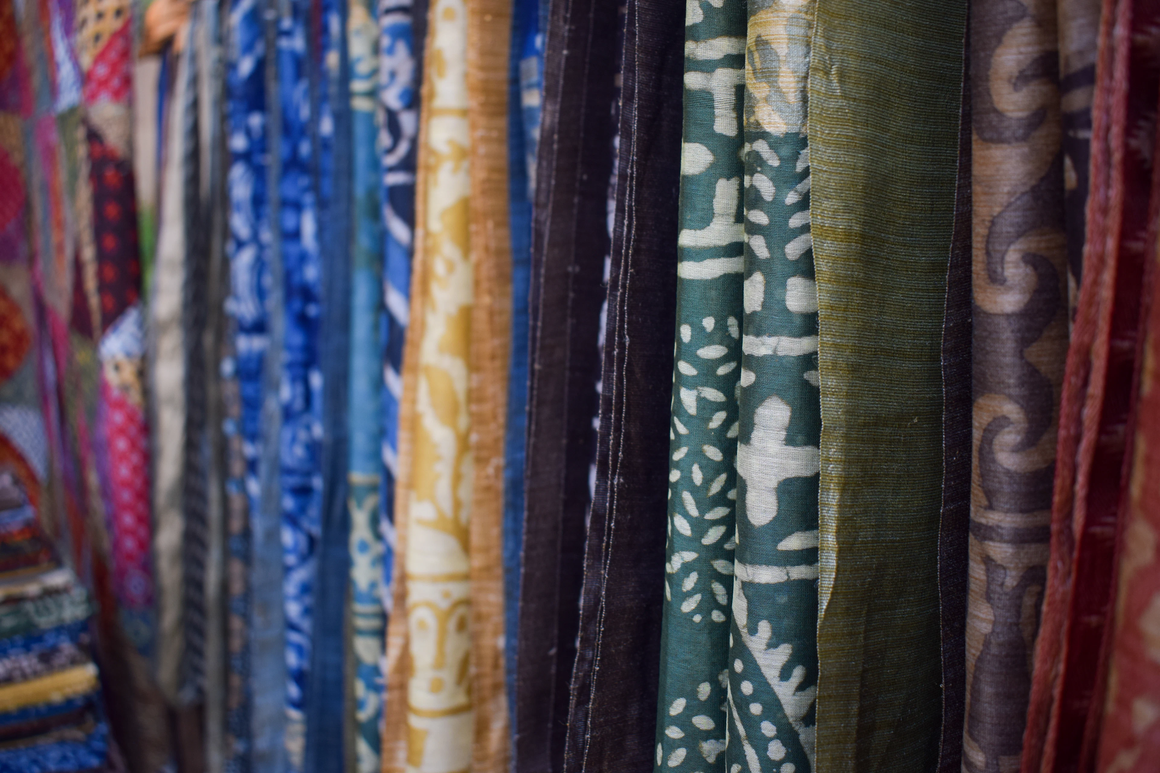 A row of block-printed fabrics in blue patterns hanging to dry.