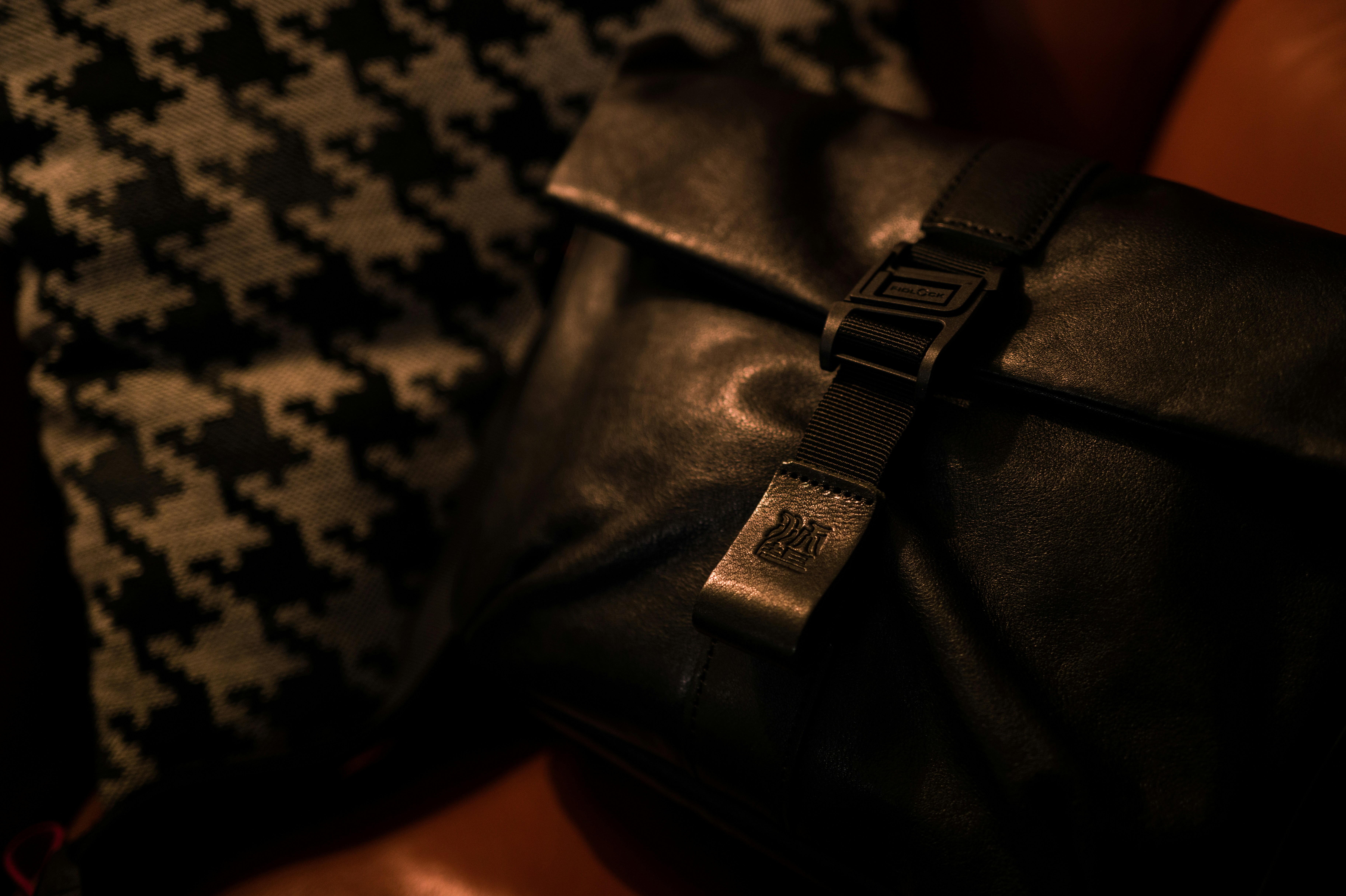 Black leather pouch with buckle and patterned fabric