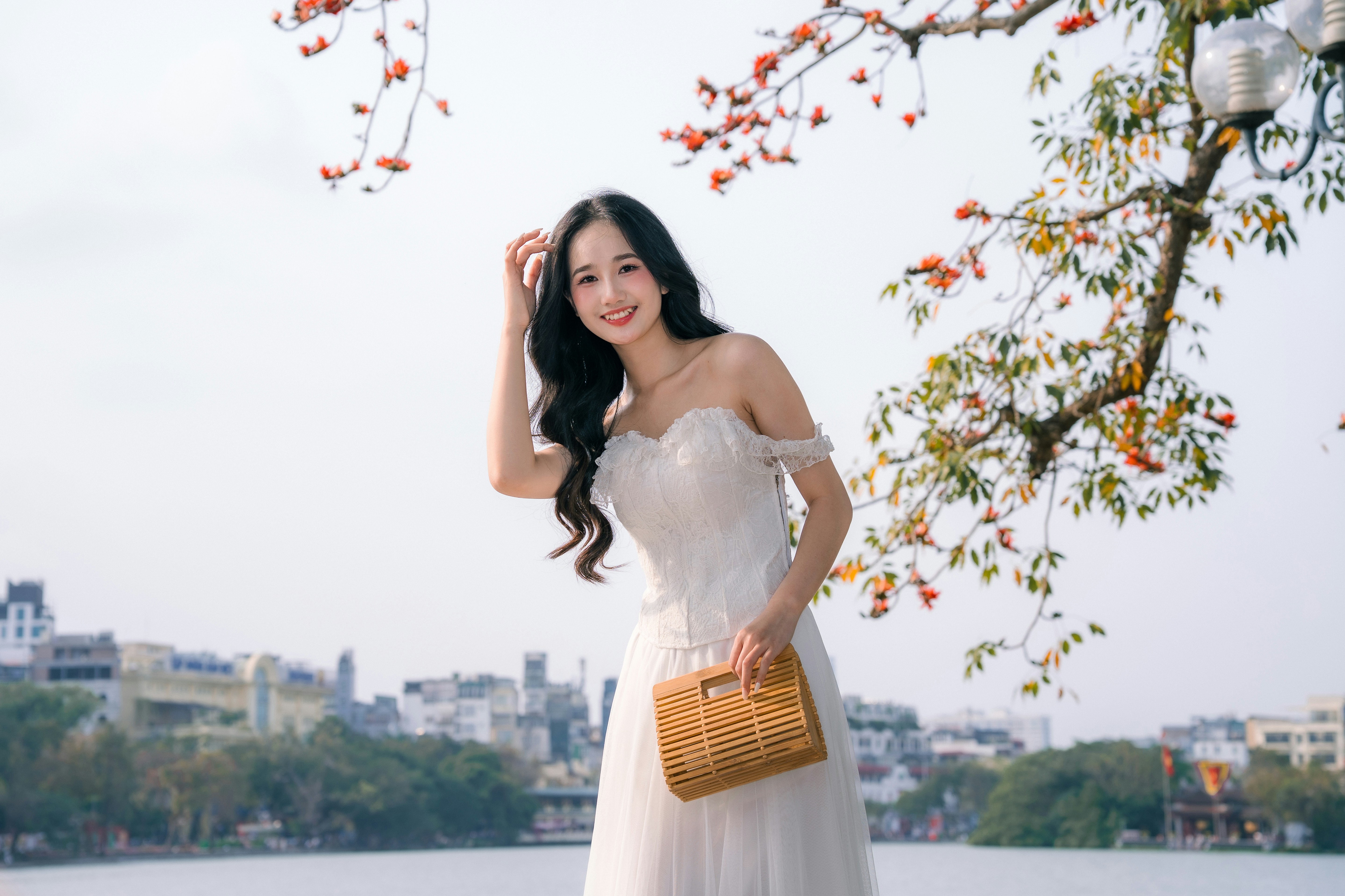 A young woman in a white dress by the water