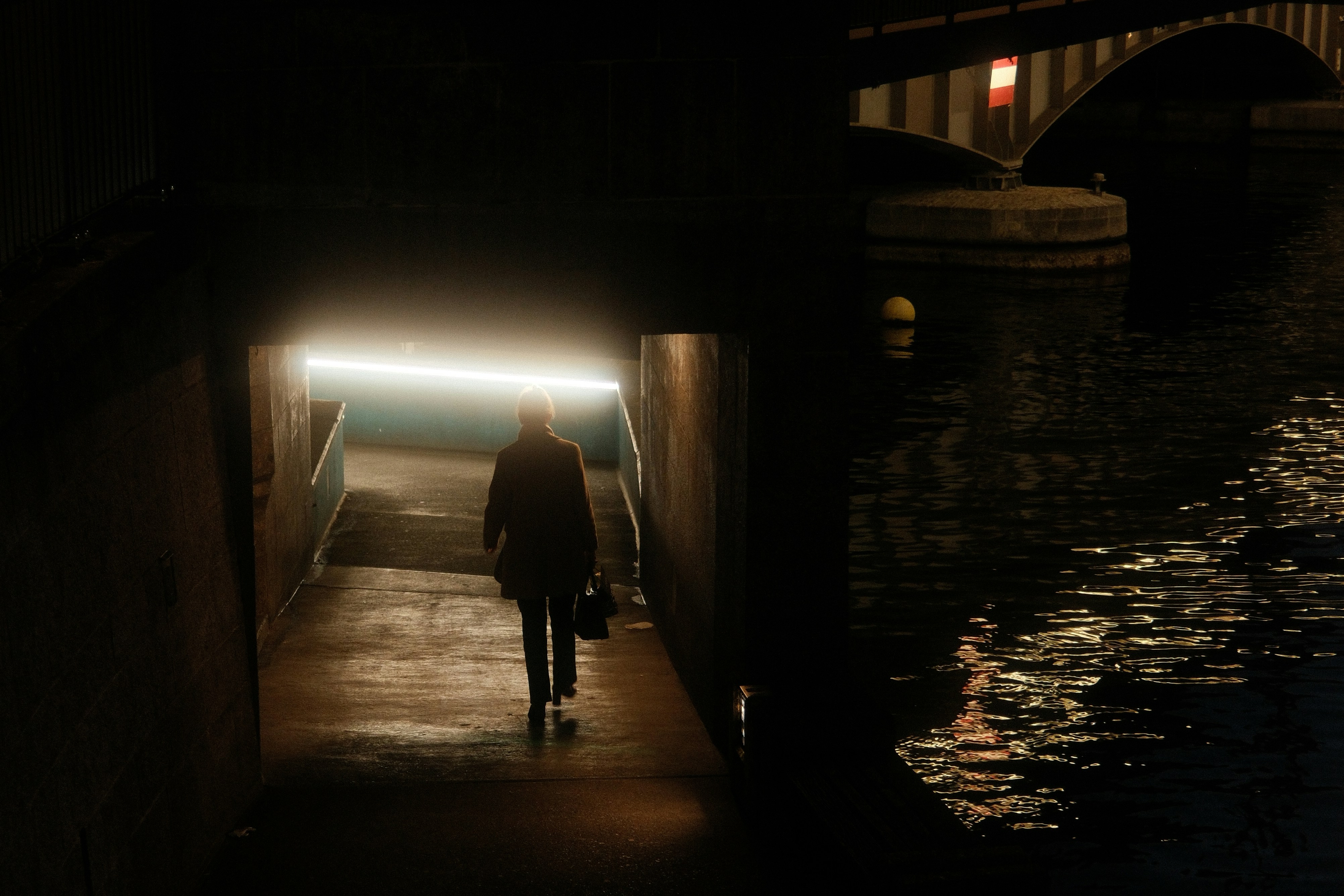 Woman walks into bright light from dark tunnel