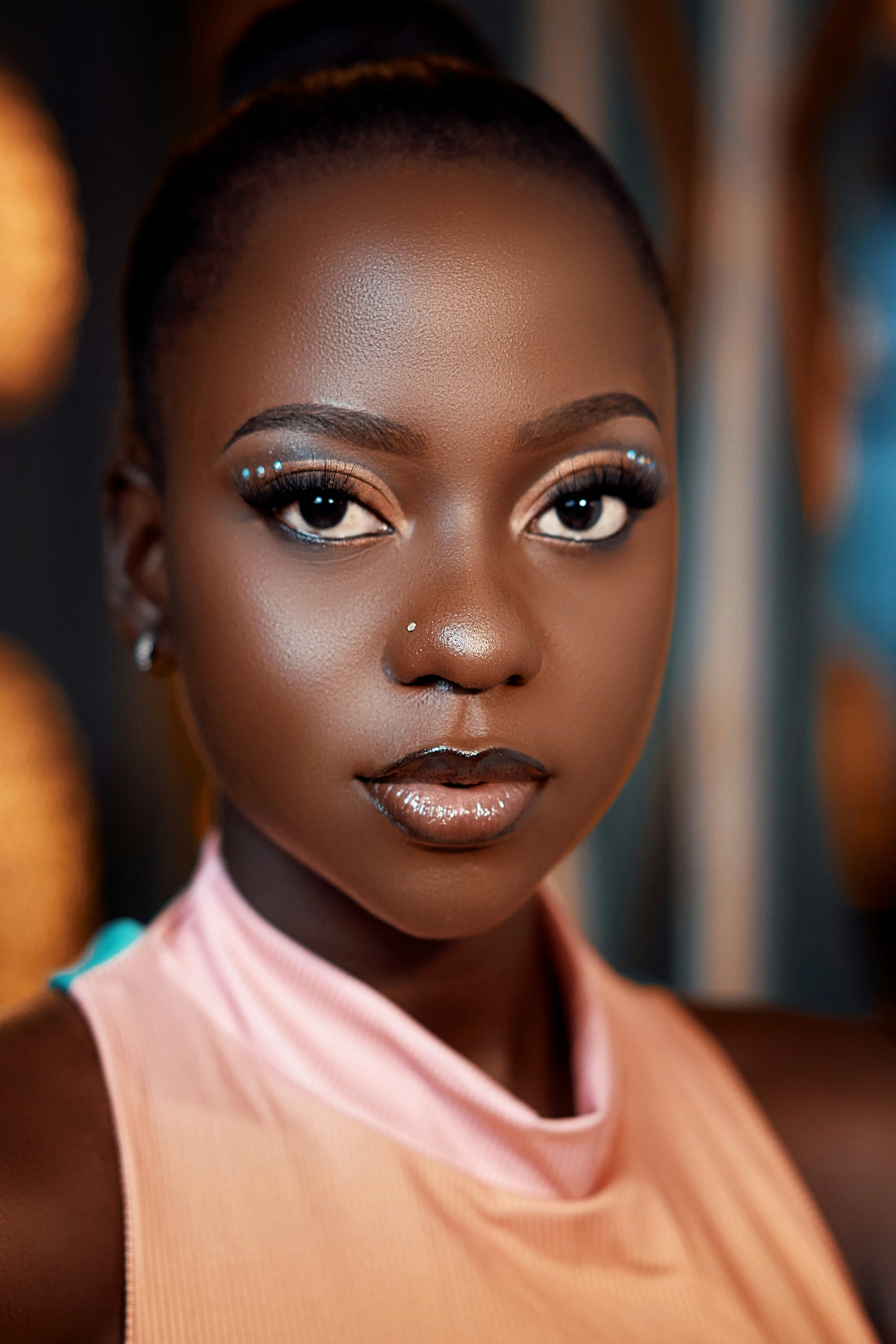 A young black woman with elaborate makeup looks forward.