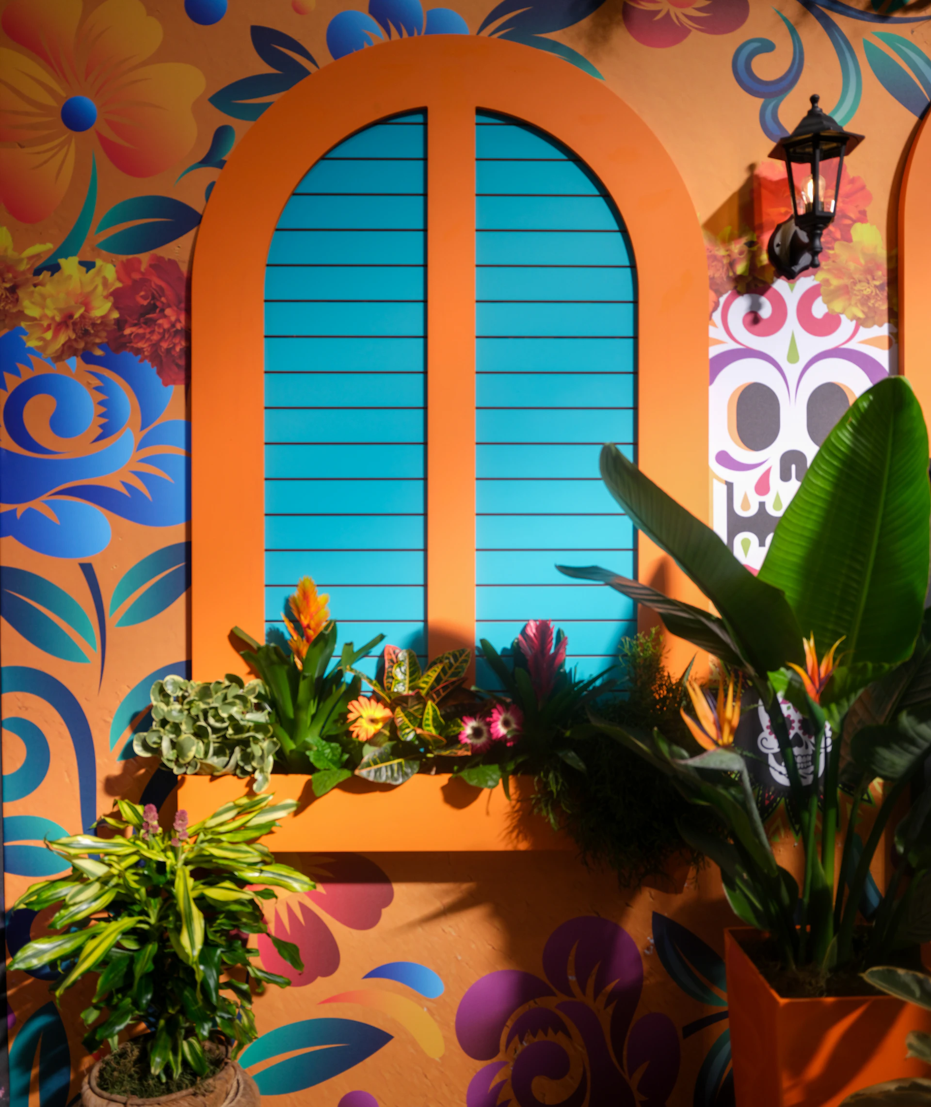 Colorful floral wall with arched window and plants