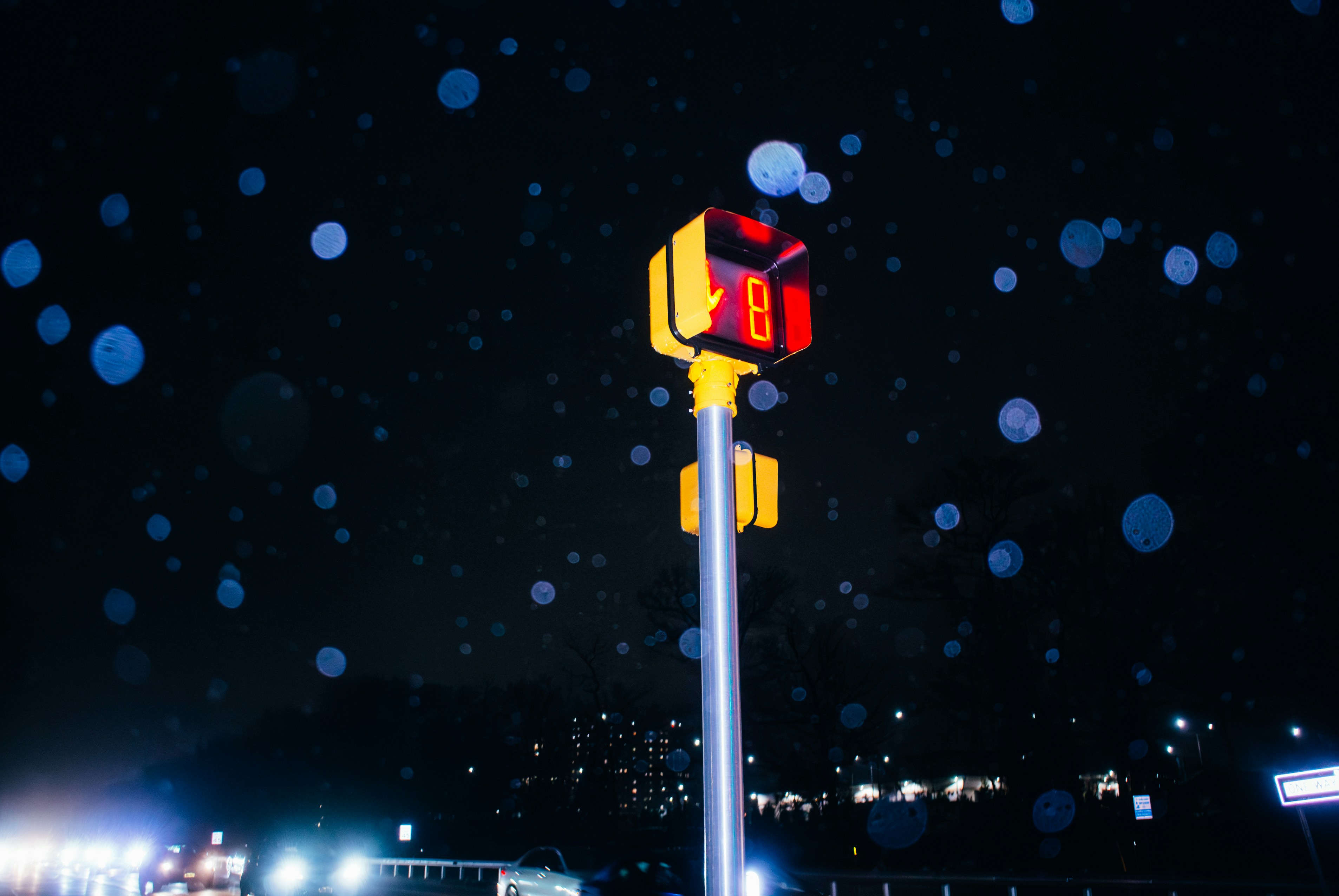 A pedestrian signal shows the number eight at night.