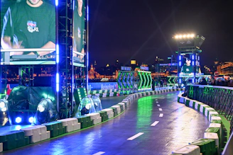 A brightly lit race track at night with green accents