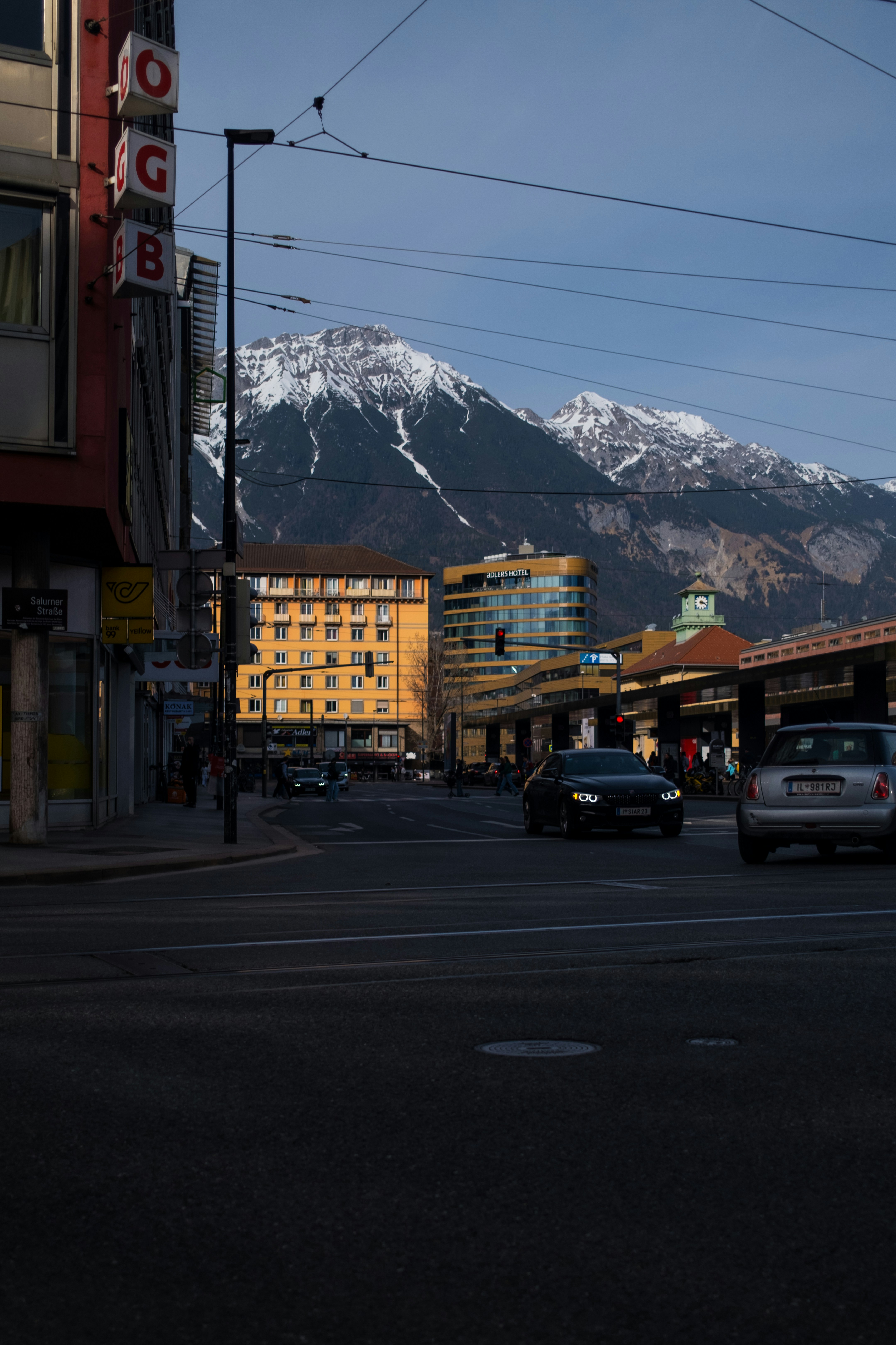 Cars on a street with snowy mountains in background