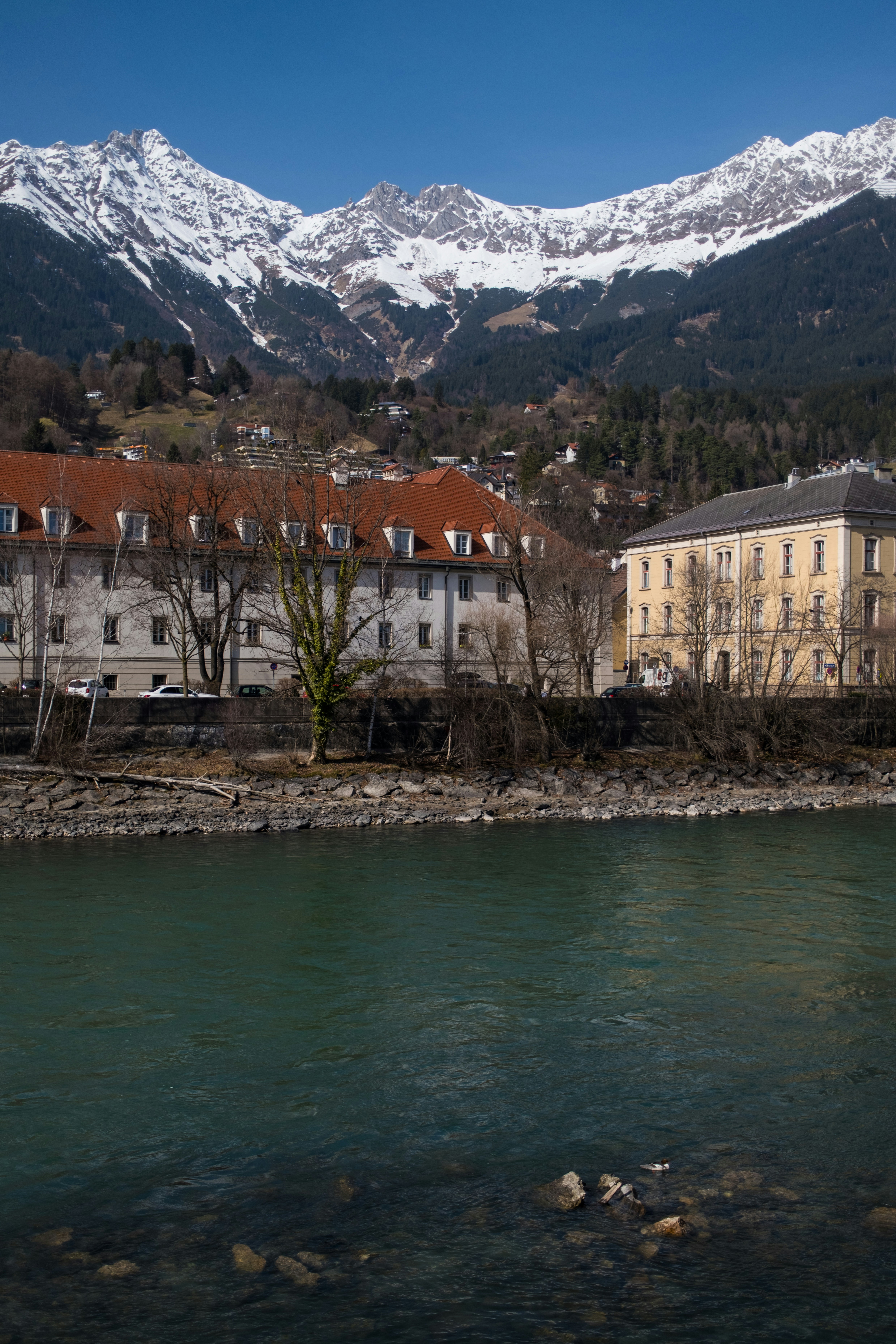 Snow-capped mountains overlook a town by a river