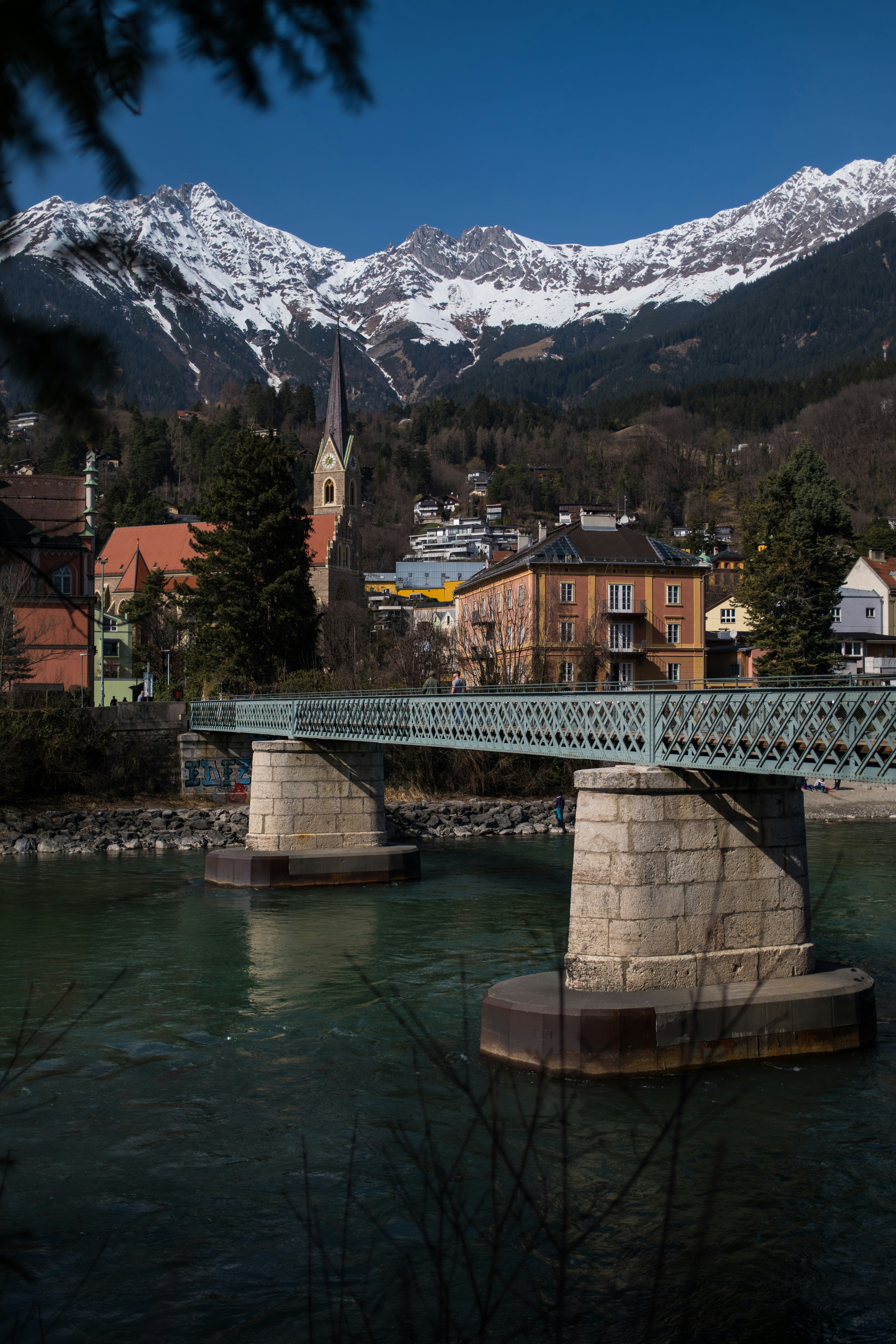Bridge over a river with mountains in the background.